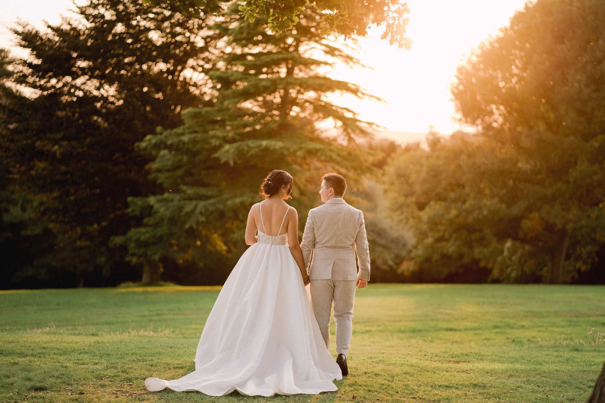 Bride and groom smiling walk off in to the sunset on their wedding day at Hartsfield Manor.