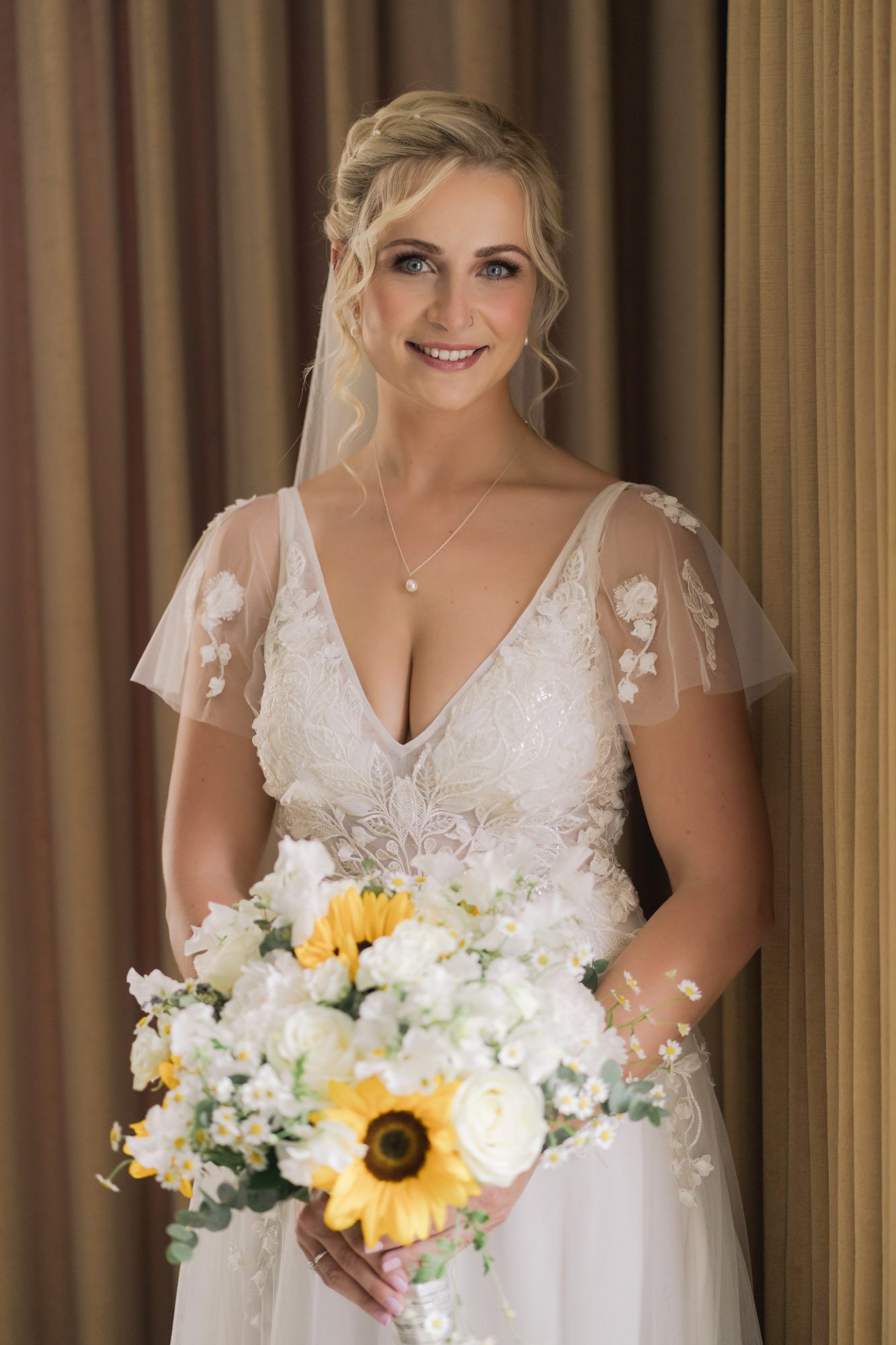 A bride in a beautiful wedding dress holding her bouquet of flowers at Hartsfield Manor.