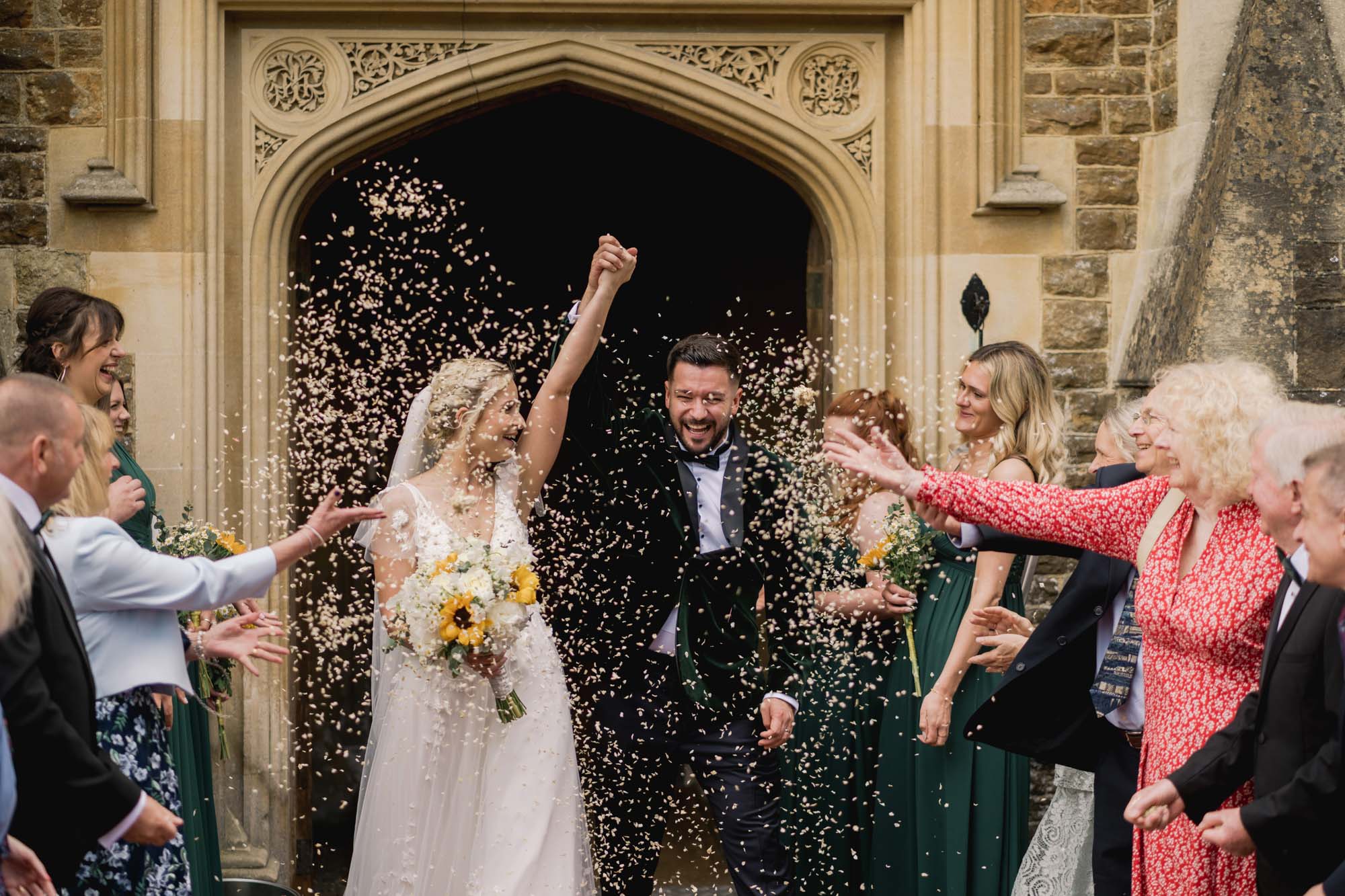 Wedding guests throw confetti at the bride and groom on their wedding day at Hartsfield Manor.