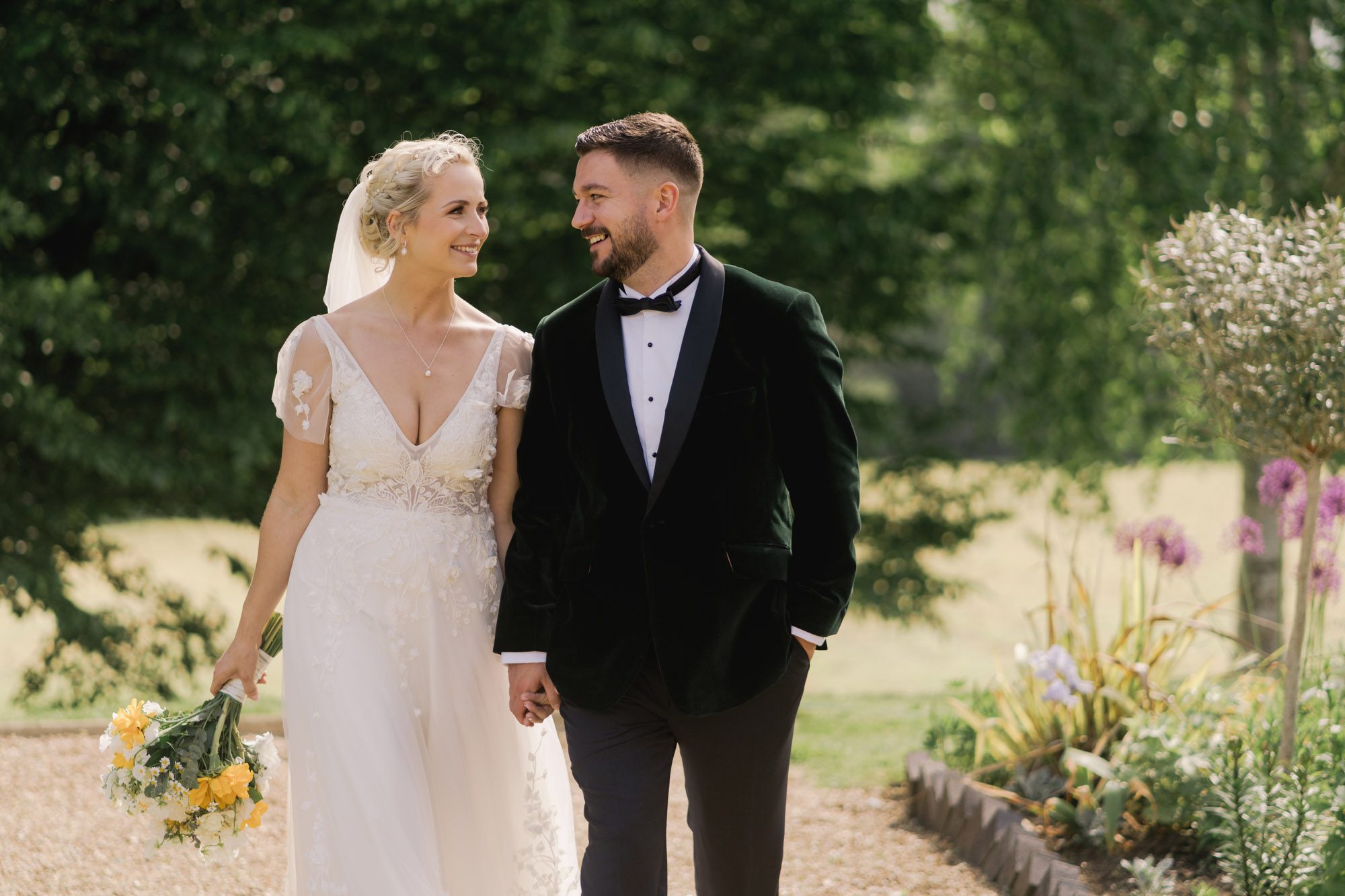 Bride and groom smiling whilst they take a stroll on their wedding day at Hartsfield Manor.
