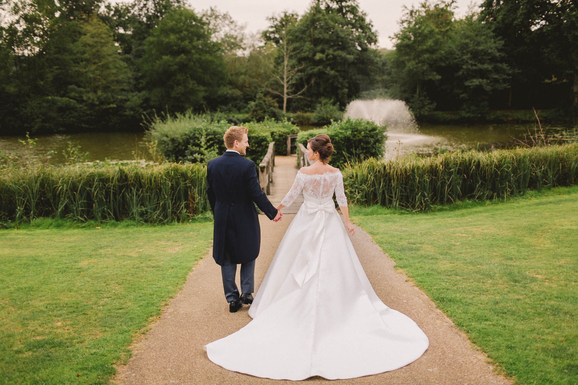 Bride and groom smiling whilst they take a stroll on their wedding day at Ashdown Park.