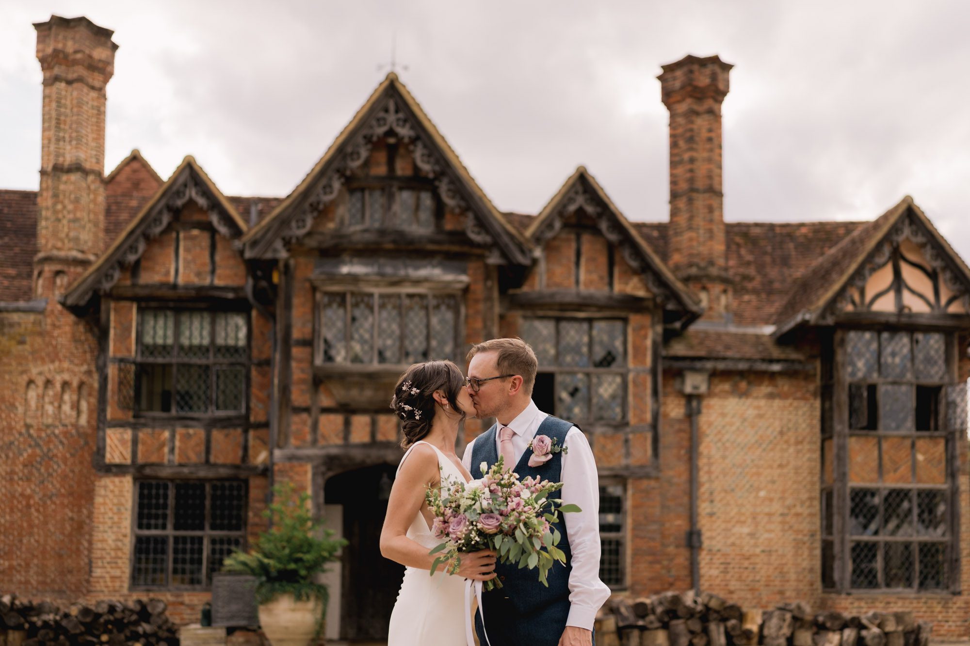 A bride and groom kiss on their wedding day with Dorney Court in the bsackground.