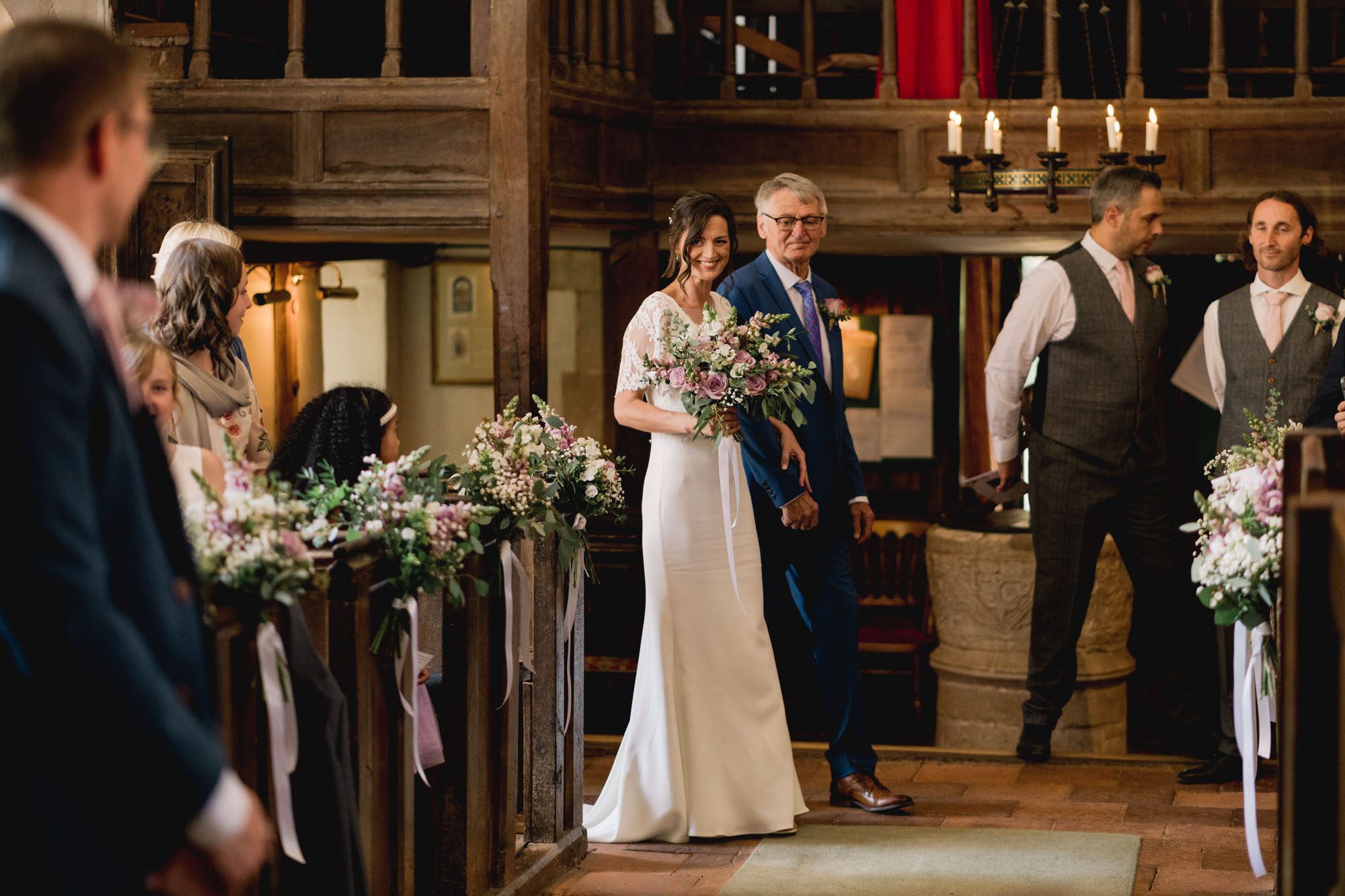 A bride walking down the aisle with her father at Dorney Court in Buckinghamshire.