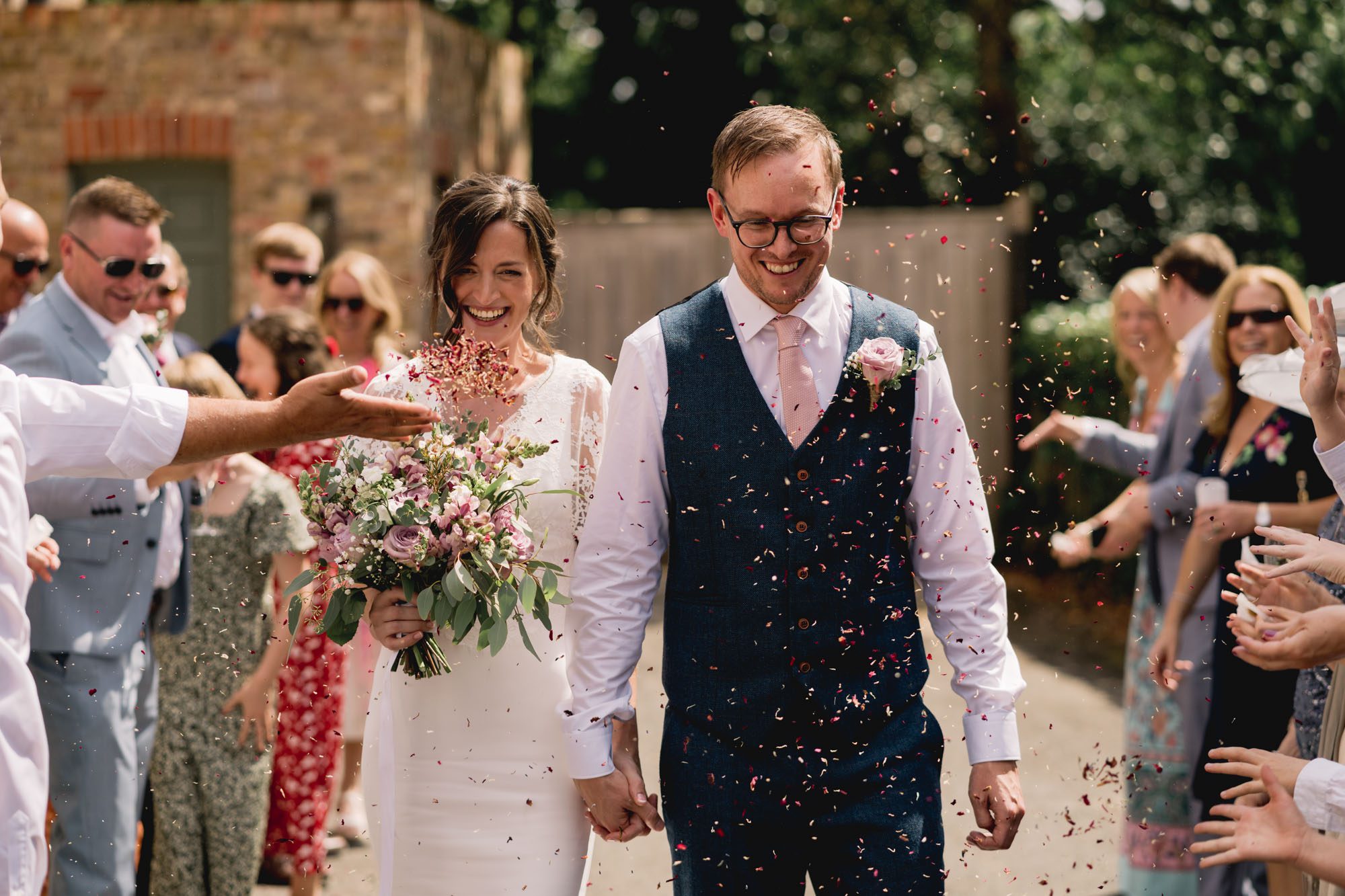 A bride and groom have lots of confetti thrown at them on their wedding day at Dorney Court in Buckinghamshire.