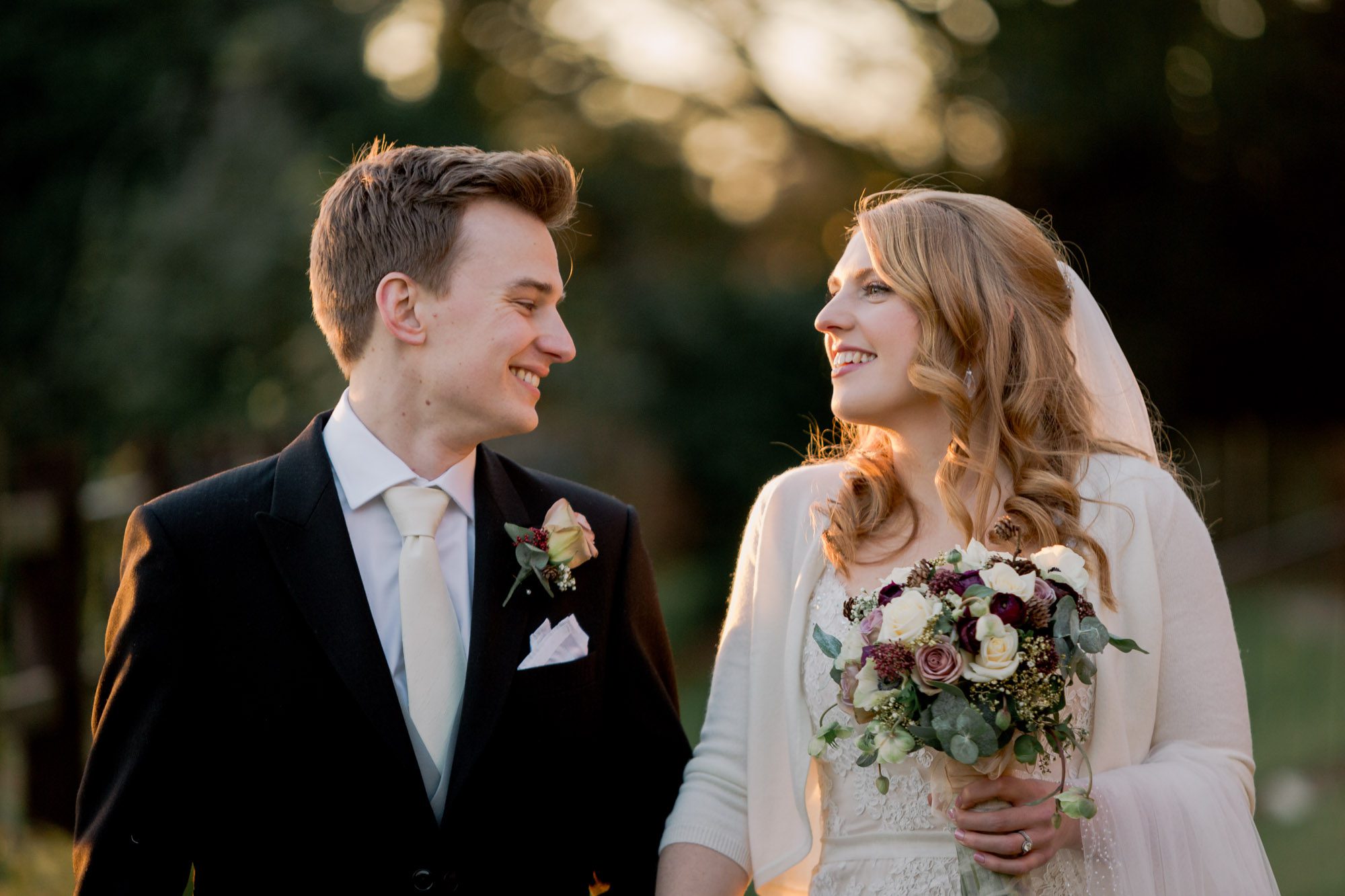 Bride and groom smiling whilst they take a stroll on their wedding day at Nutfield Priory Wedding Venue in Surrey.