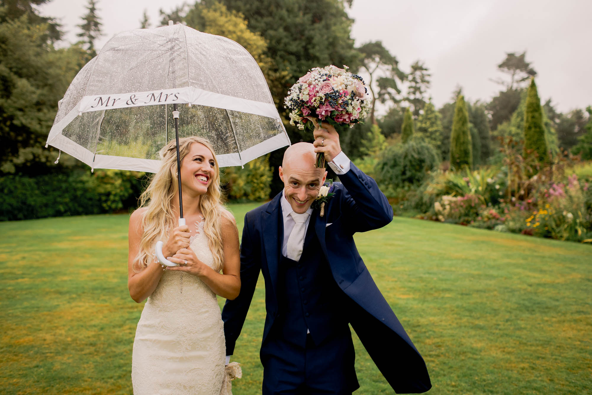 Bride and groom smiling whilst they take a stroll on their wedding day at Barnett Hill in Surrey.