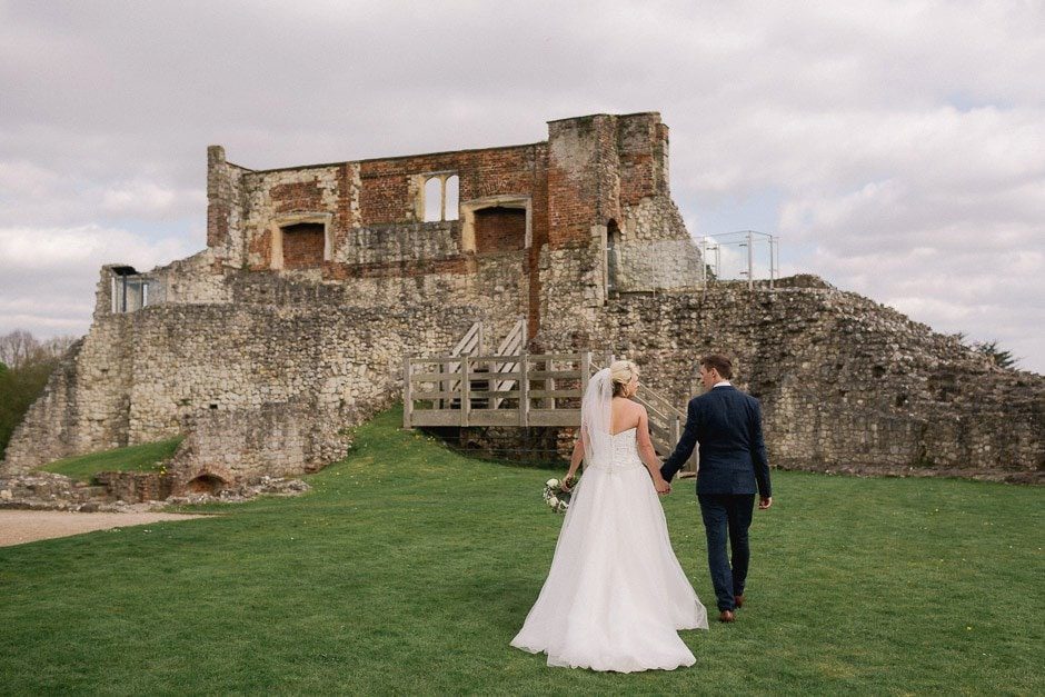 newlyweds take a stroll together at Farnham Castle on the lawn.