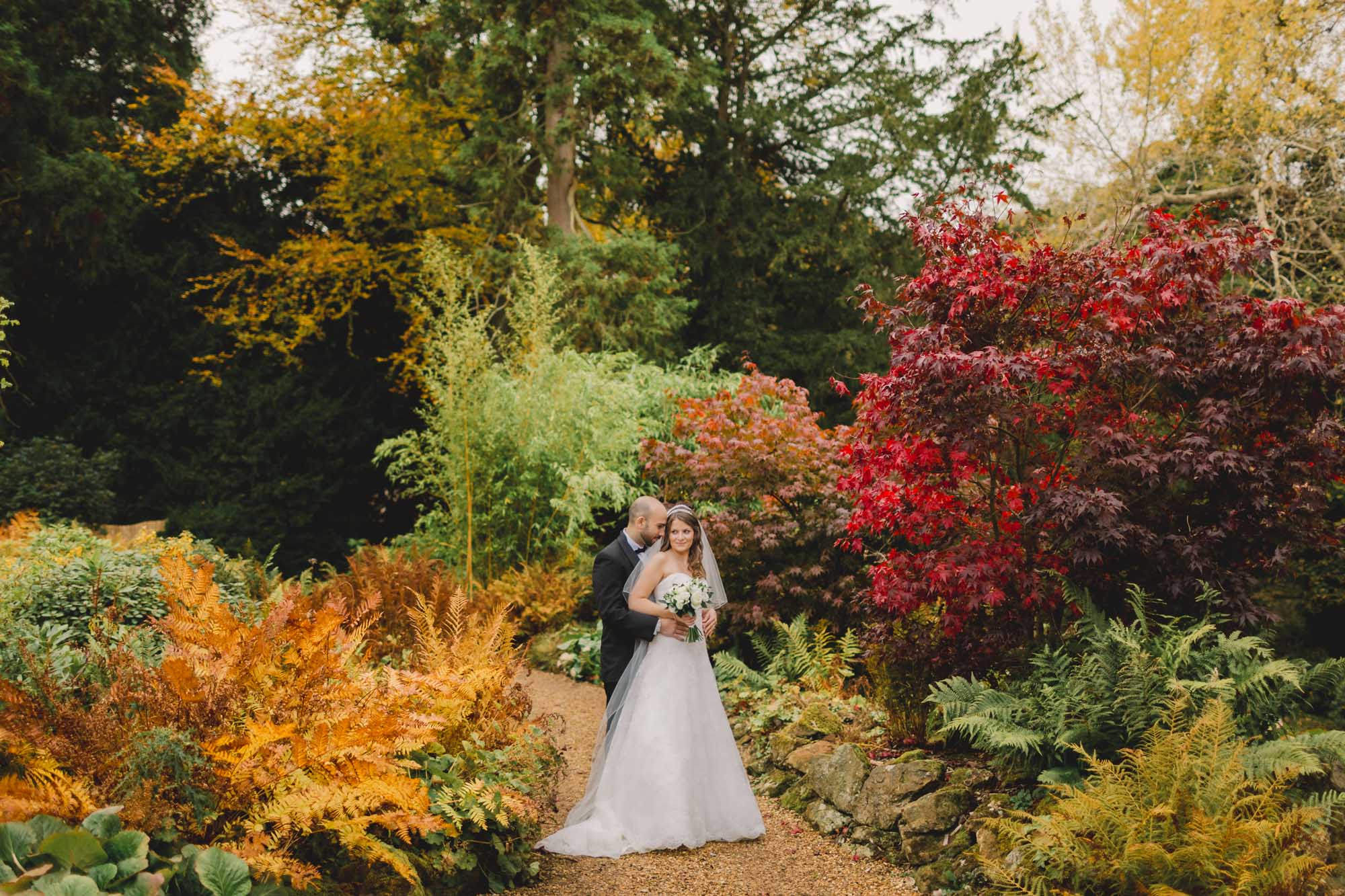 Bride and groom hug closely on their wedding day in Autumn at Wotton House.