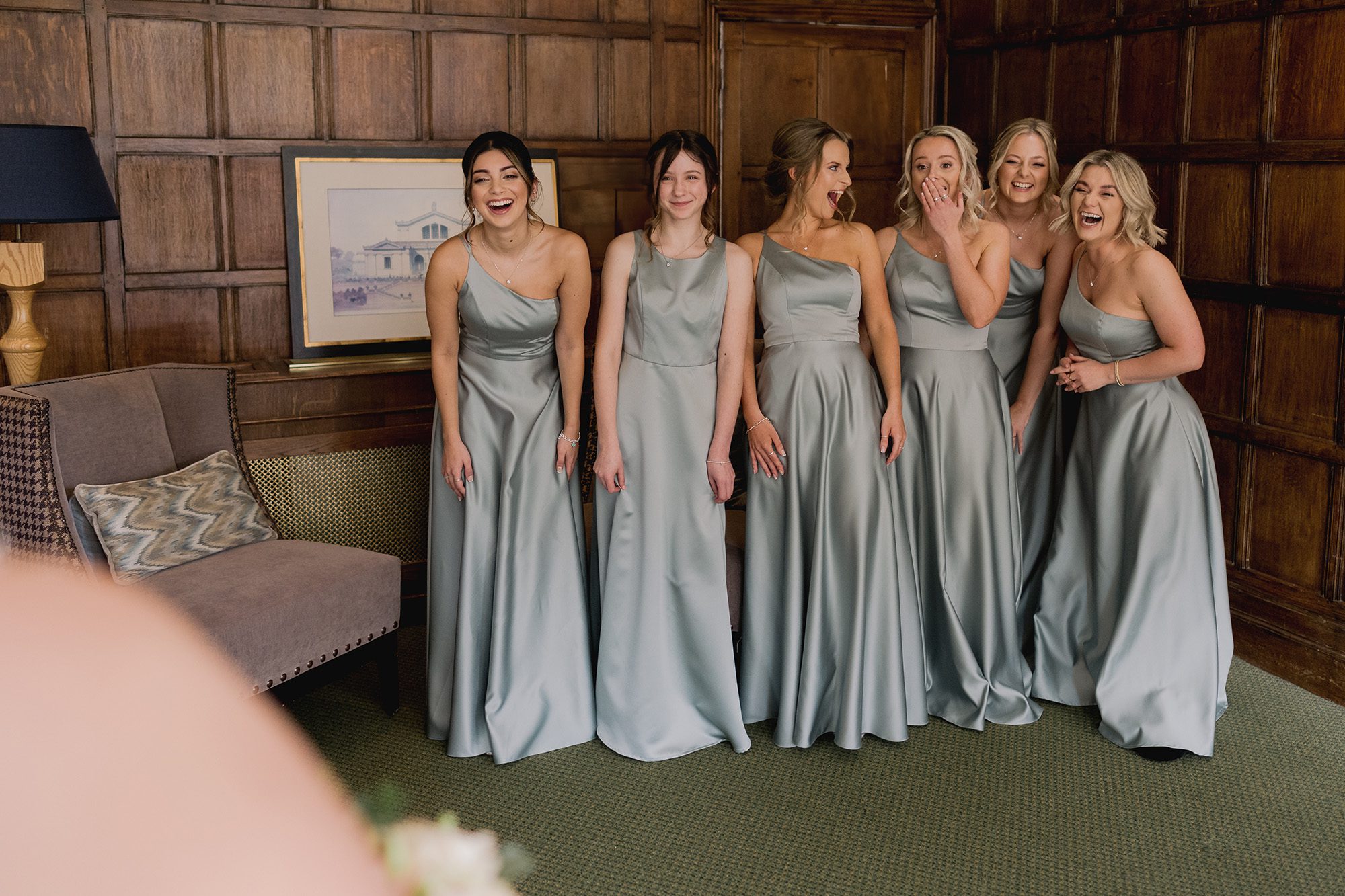 Reportage photography as bridesmaids are excited as they see the bride for the first time in her dress.