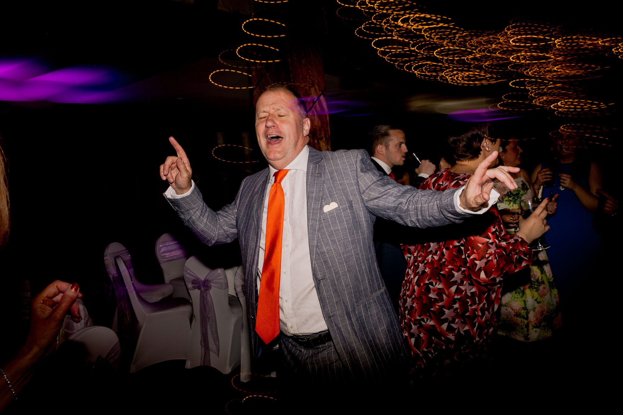 A guest dancing on the dance floor at a wedding at Great Fosters.