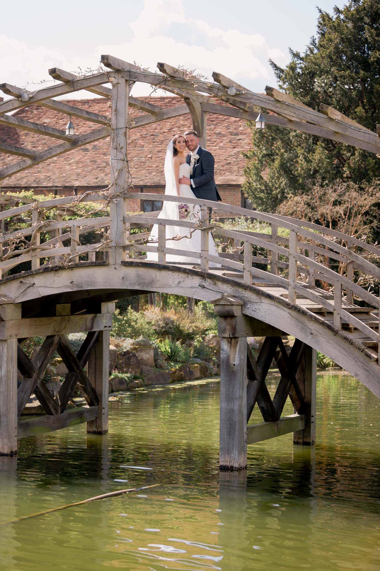 Bride and groom on the bridge at Great Fosters.