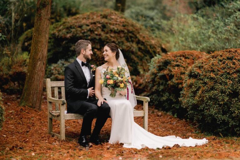 Bride and groom hug closely on a bench on their wedding day at Ramster Hall.