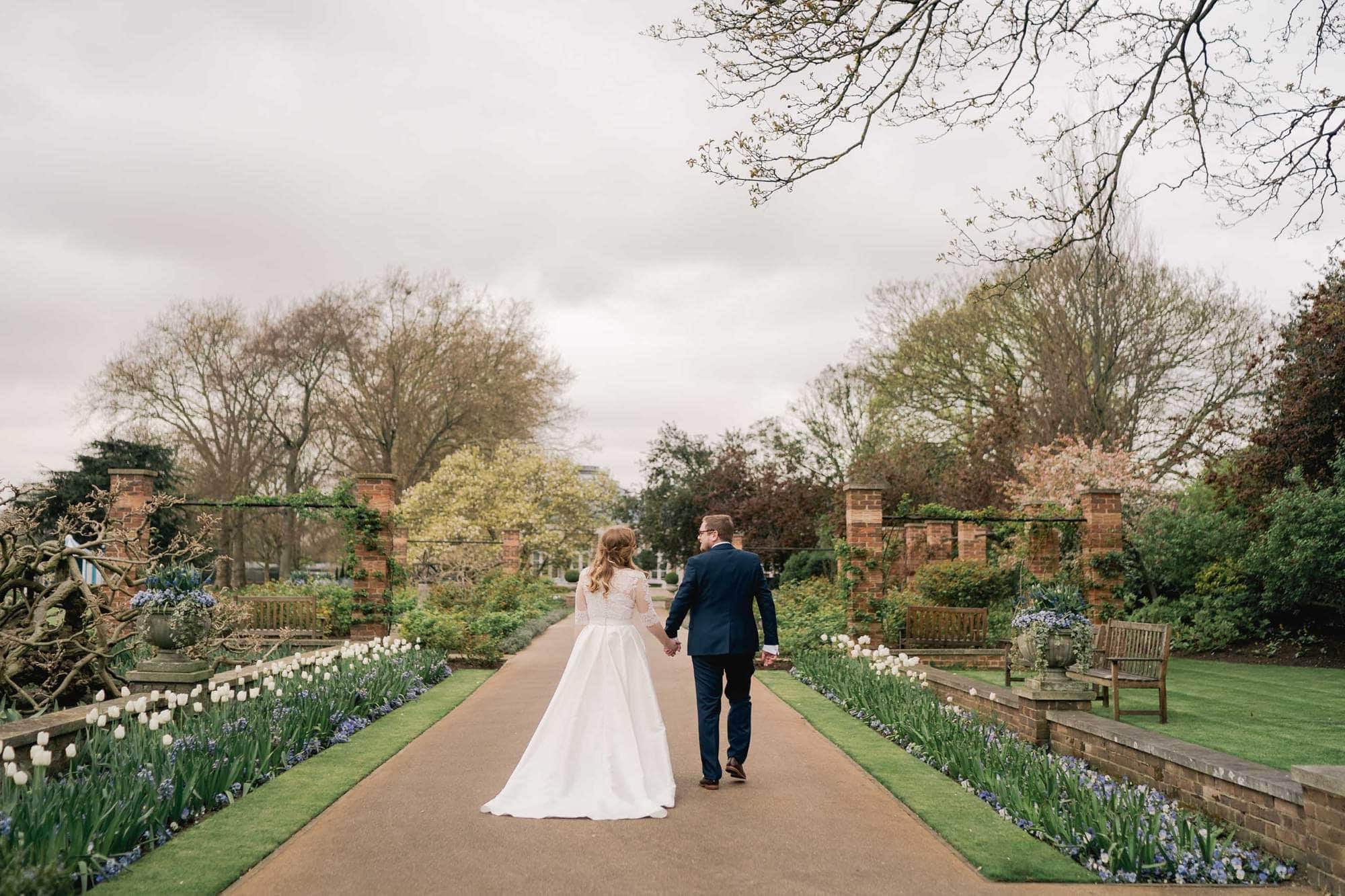 Bride and groom smiling whilst they take a stroll on their wedding day at the Hurlingham Club in London