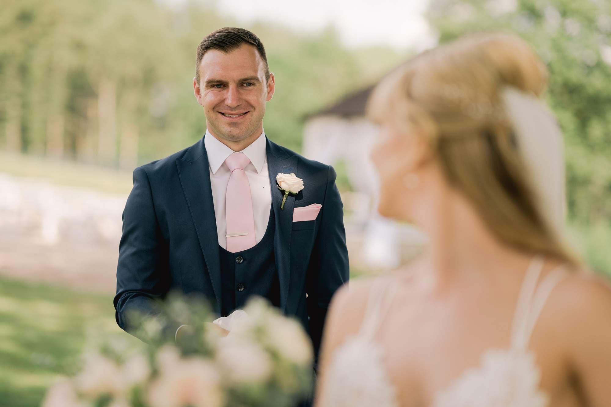 A groom smiles at his wife on their wedding day.