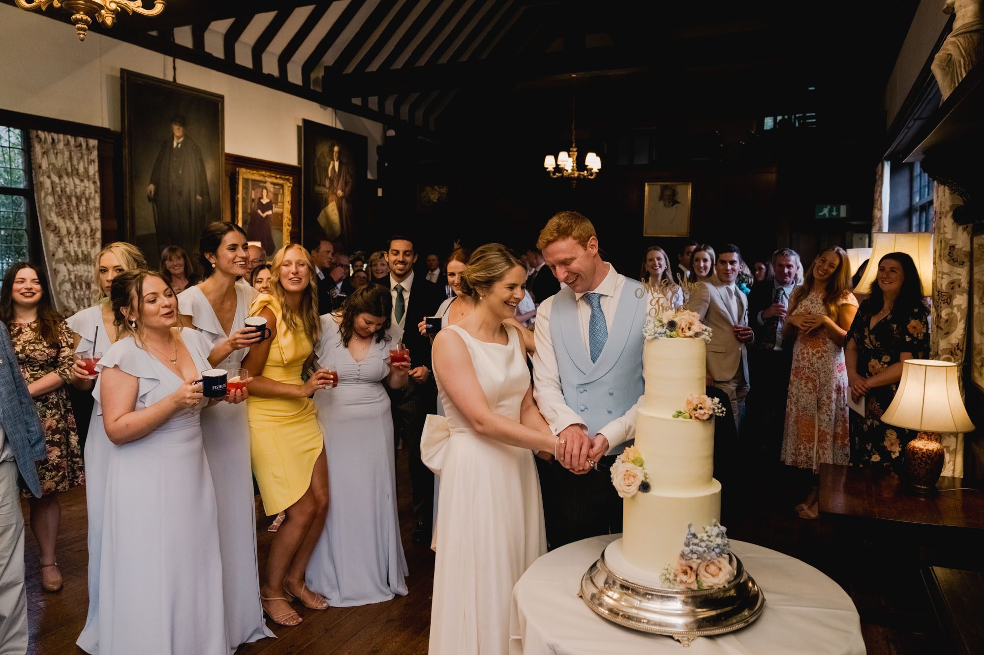 Bride and Groom cut the cake at Ramster Hall in Surrey.