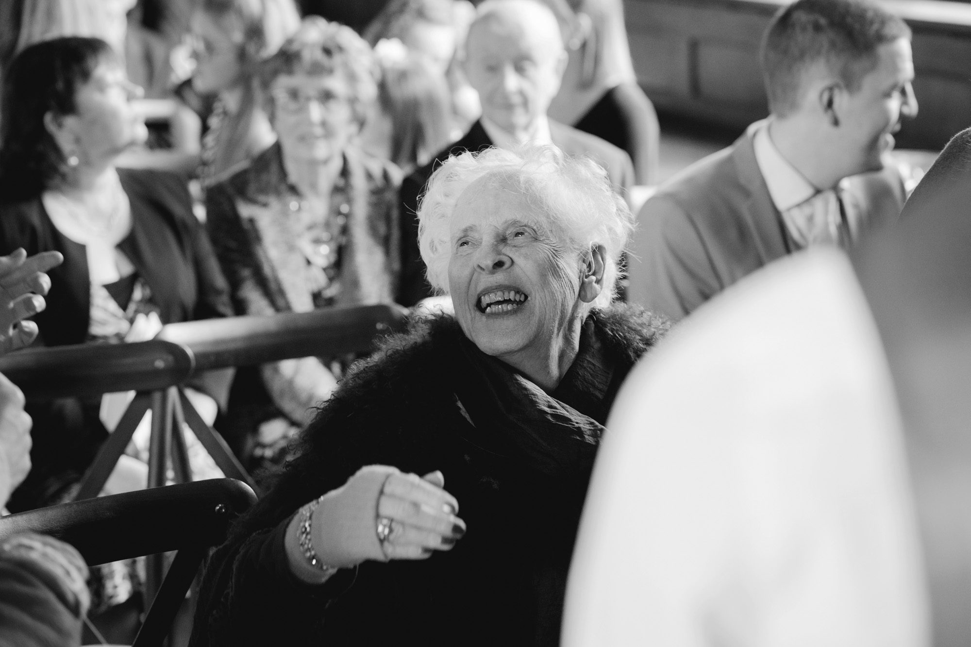 A guest laughing at a wedding.