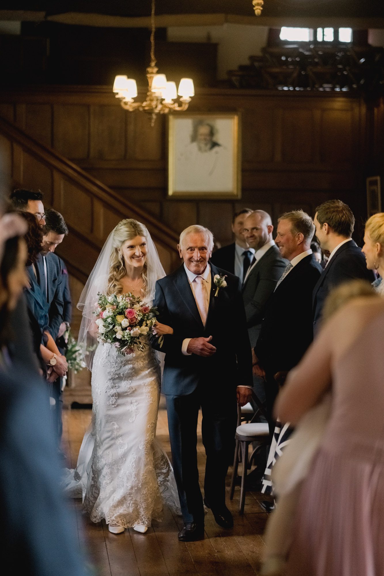 Bride walks down the aisle with her father in the Great Drawing Room at Ramster Hall.