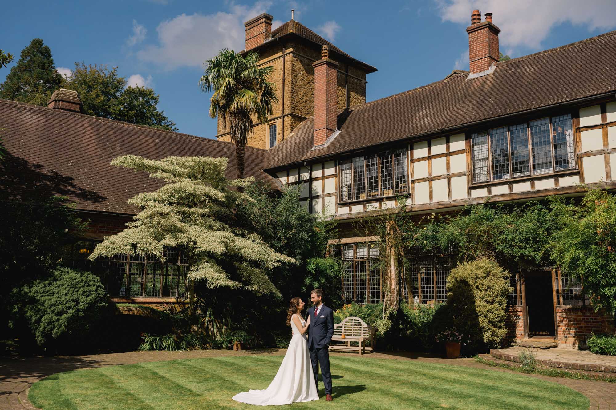 Bride and groom stare lovingly in to each other's eyes on their wedding day in the courtyard at Ramster Hall in Surrey.