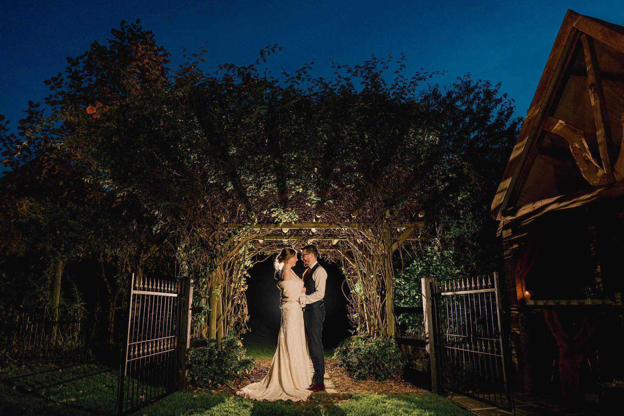 Bride and groom cuddle under a twilight sky at Rumbolds Farm in Billingshurst.