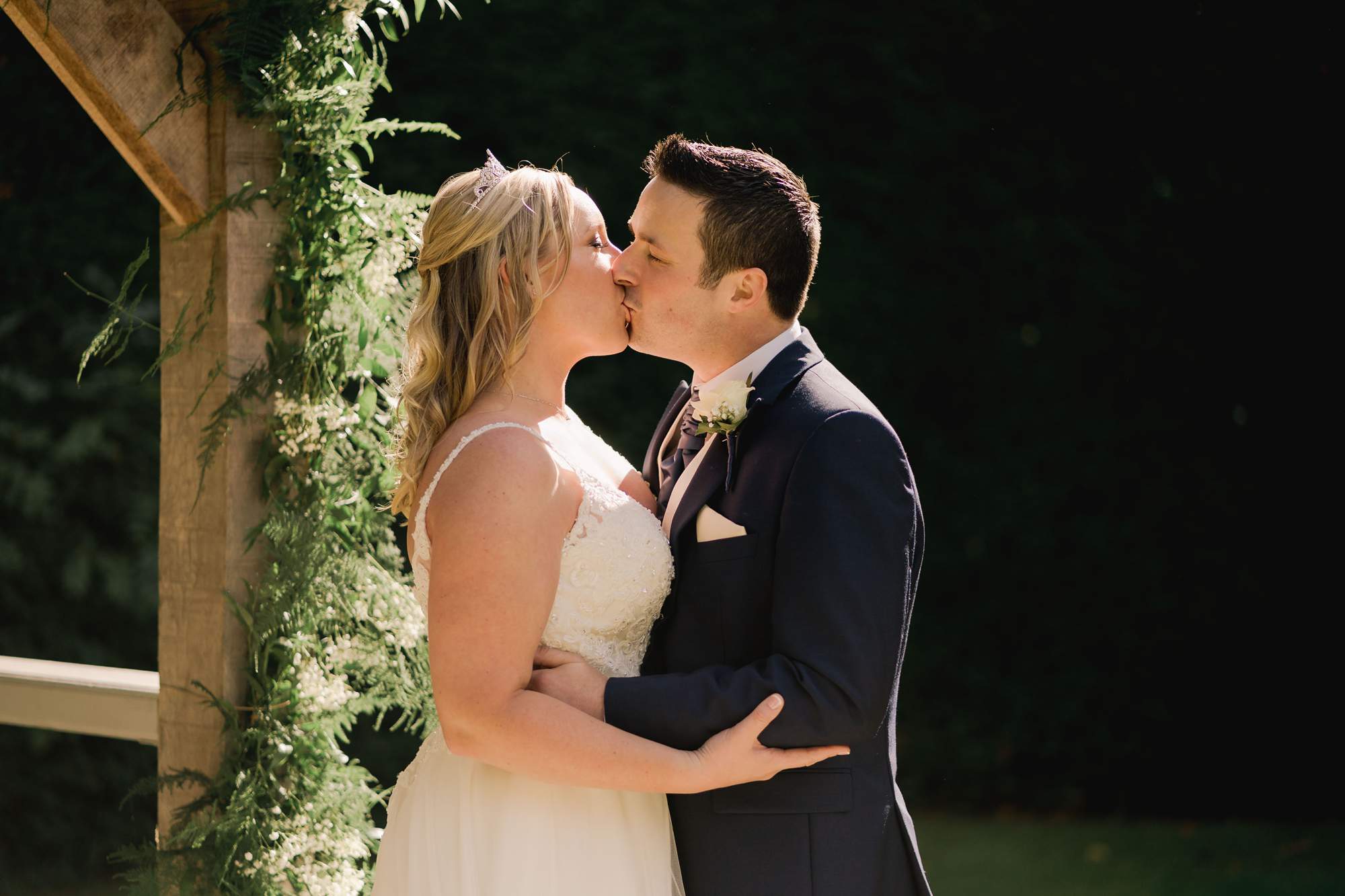 A couple kiss at their Langshott manor micro wedding