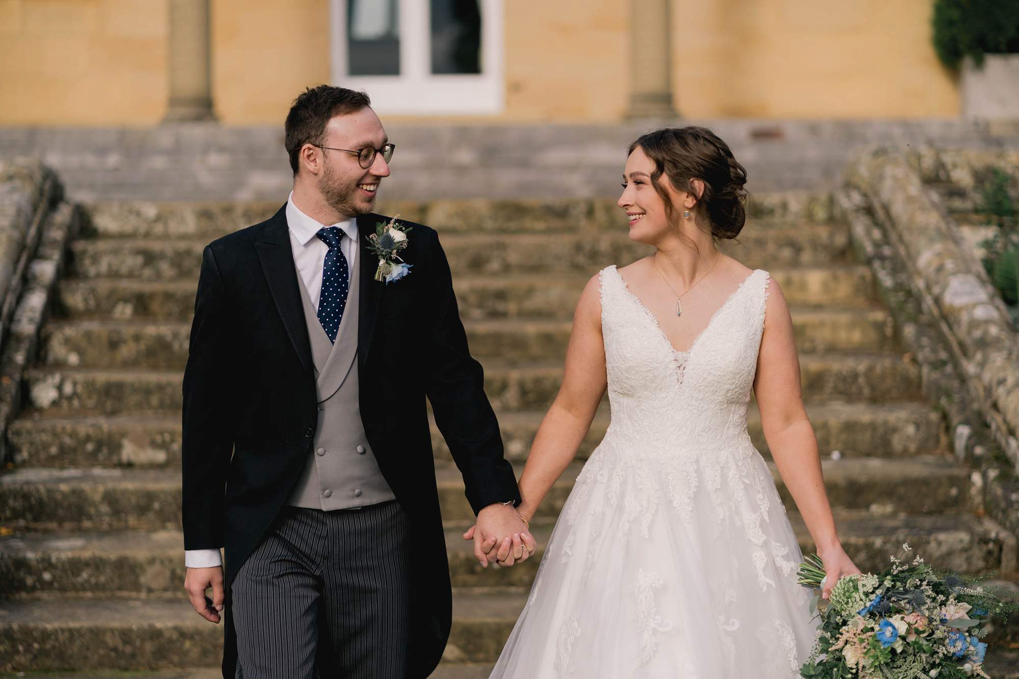 Bride and groom smiling whilst they take a stroll on their wedding day at Salomons Estate in Tunbridge Wells.