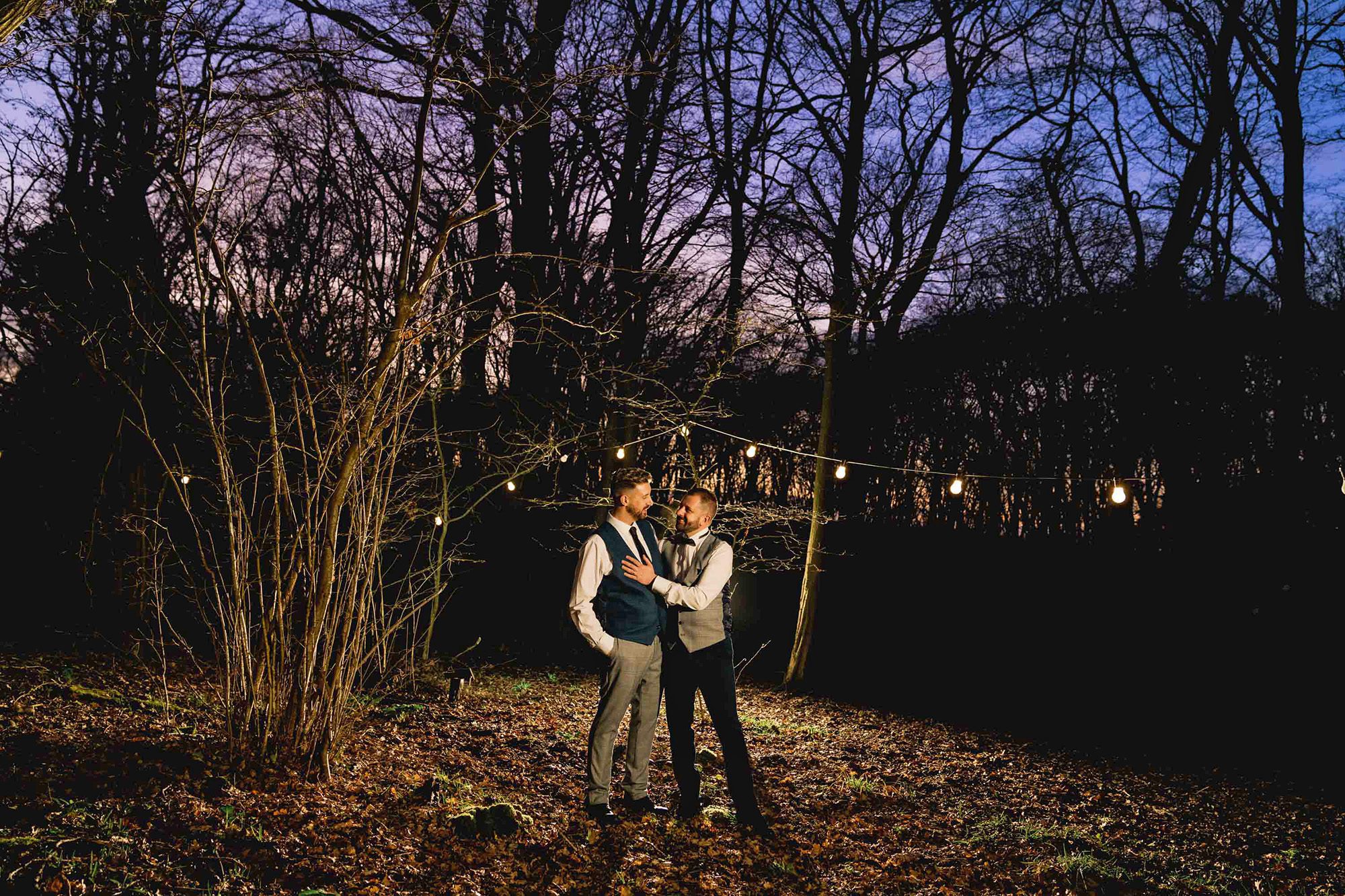Two grooms hold each other close in the evening at Wickwoods Country Club in East Sussex.