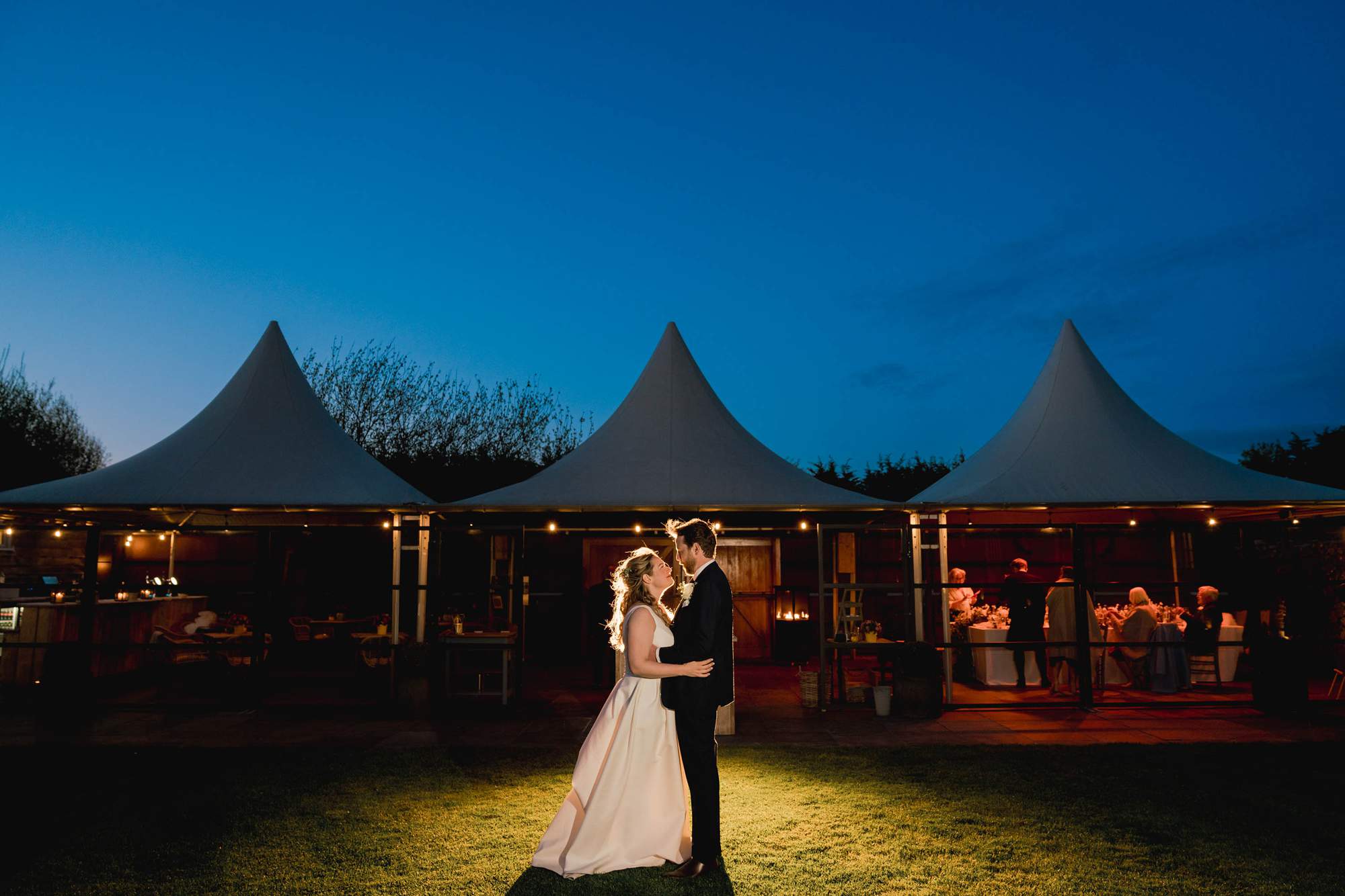 Newly married couple cuddle under the stars at Southend Barns in Sussex.