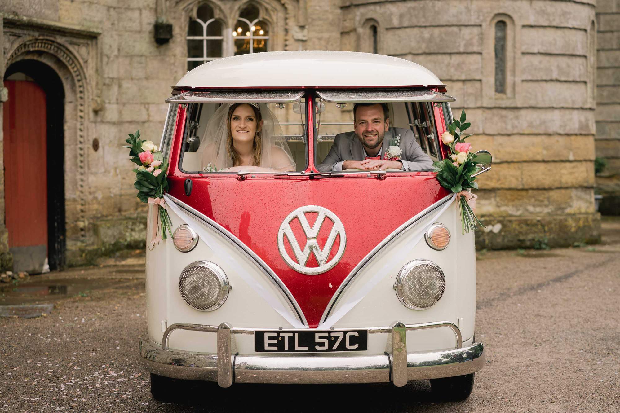 Bride and Groom pose in their hired VW campervan on their wedding day at Castle Goring in West Sussex.