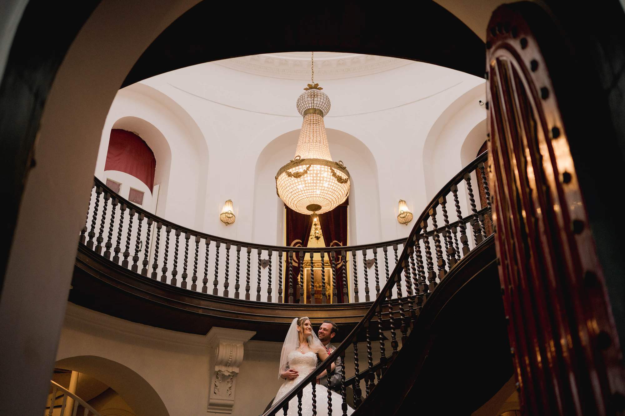 Castle Goring with a bride and groom stood on the stairs.