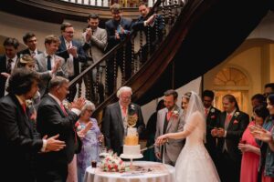 The bride and groom cut the cake at their wedding at Castle Goring in West Sussex.