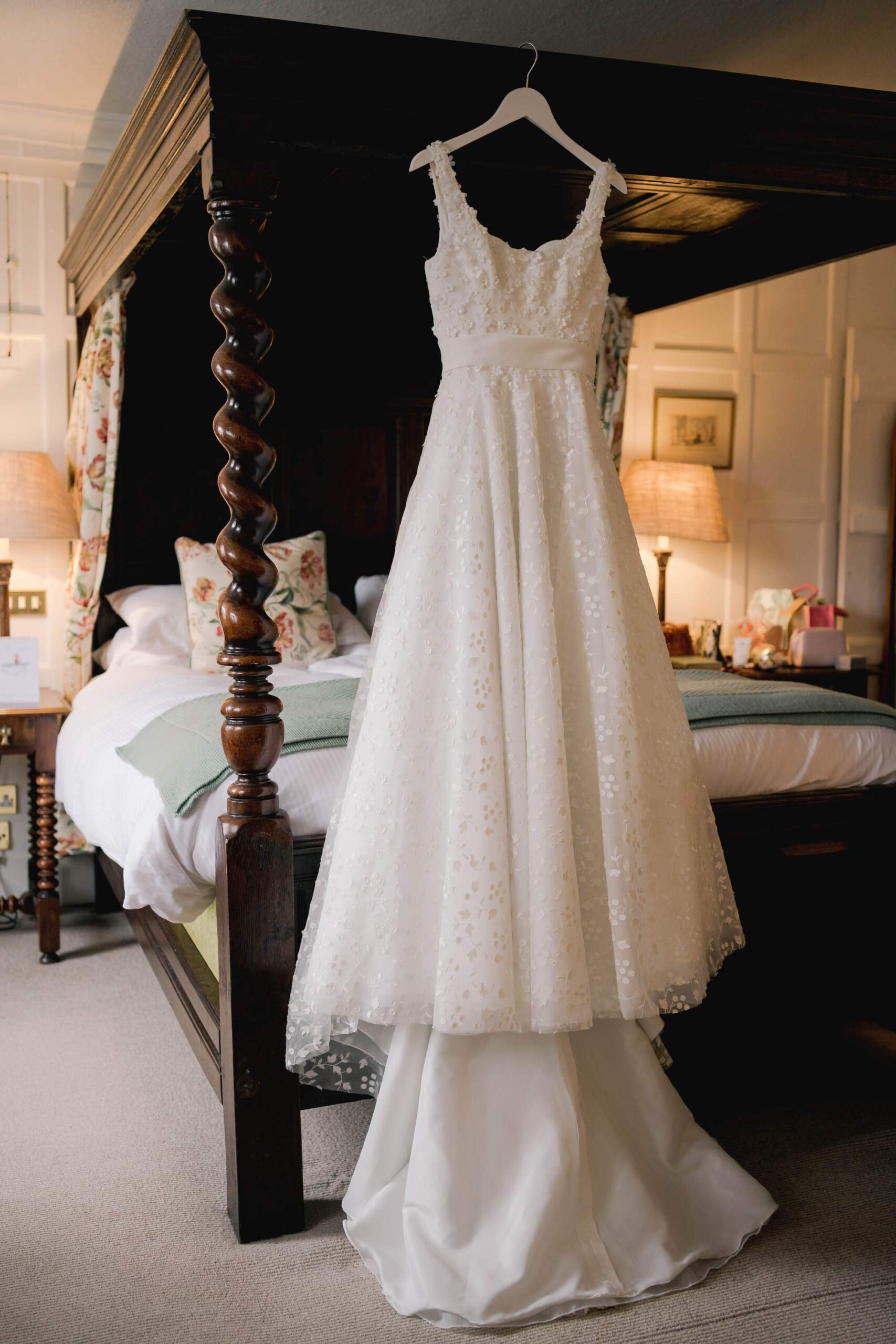 A wedding dress hanging on a four poster bed in a room at the Spread Eagle Hotel in Midhurst.