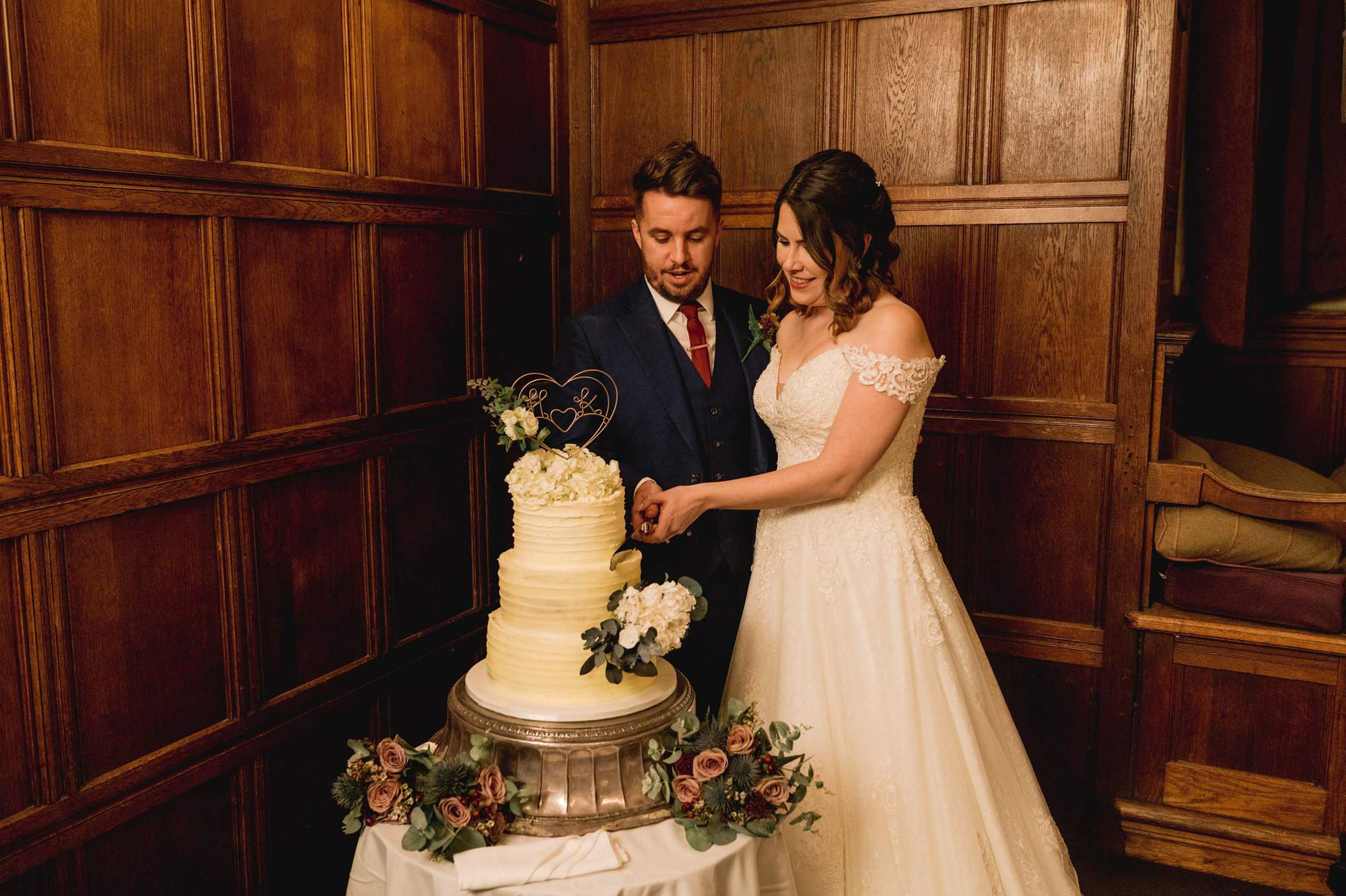 Bride and groom cut the wedding cake at Rhinefield House wedding venue in Hampshire.