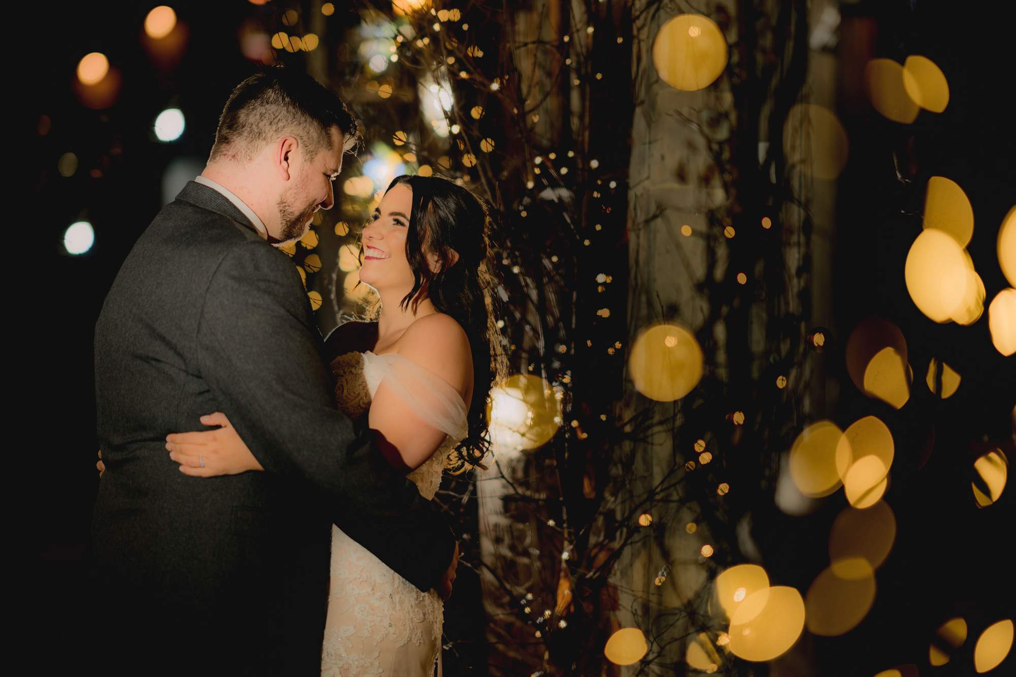 Bride and groom share a moment amongst a sea of twinkling fairly light for their magical Christmas wedding in Arundel.