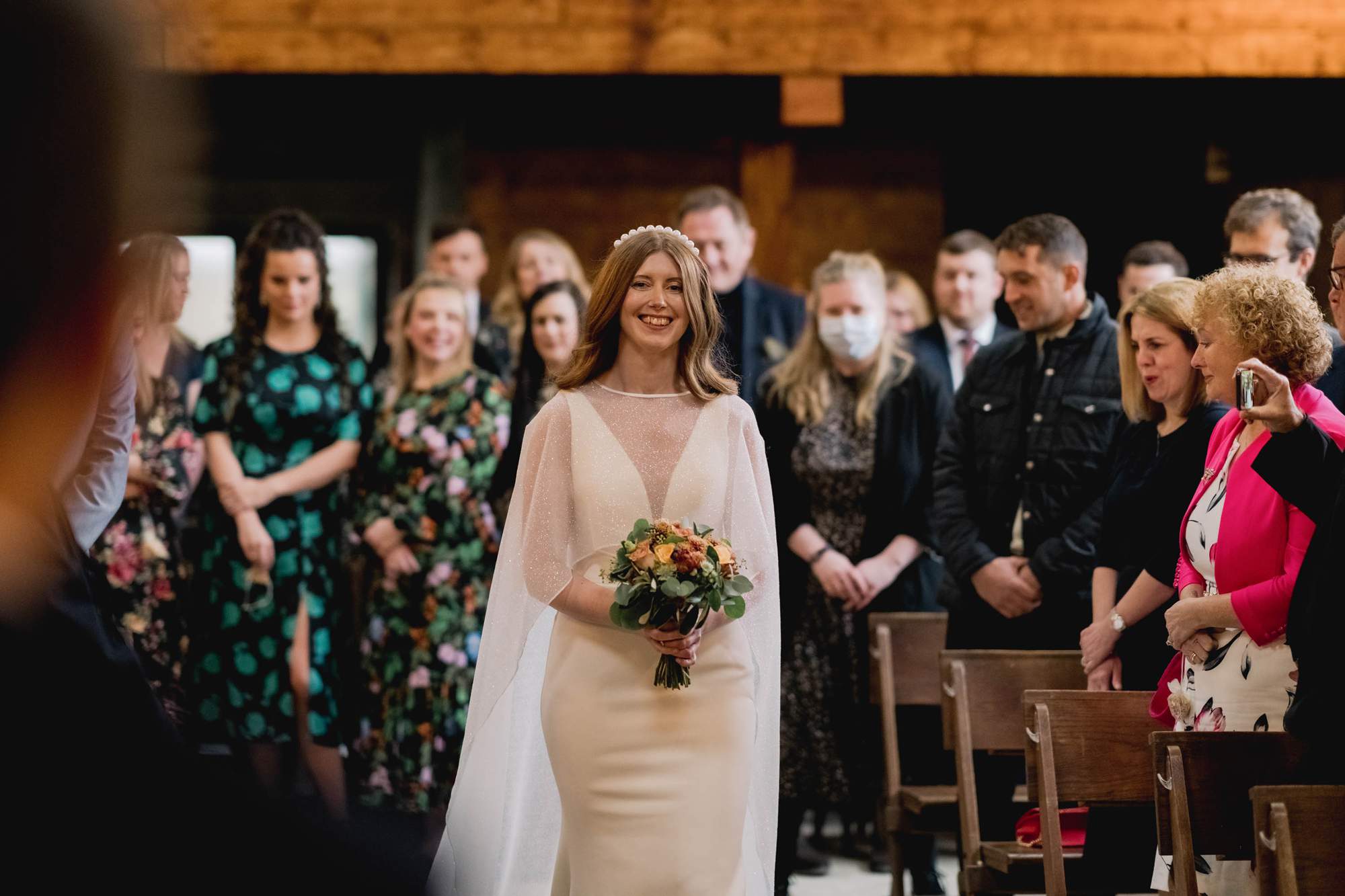 Bride walks down the aisle on her wedding day at the Barn at Botley Hill in Surrey.