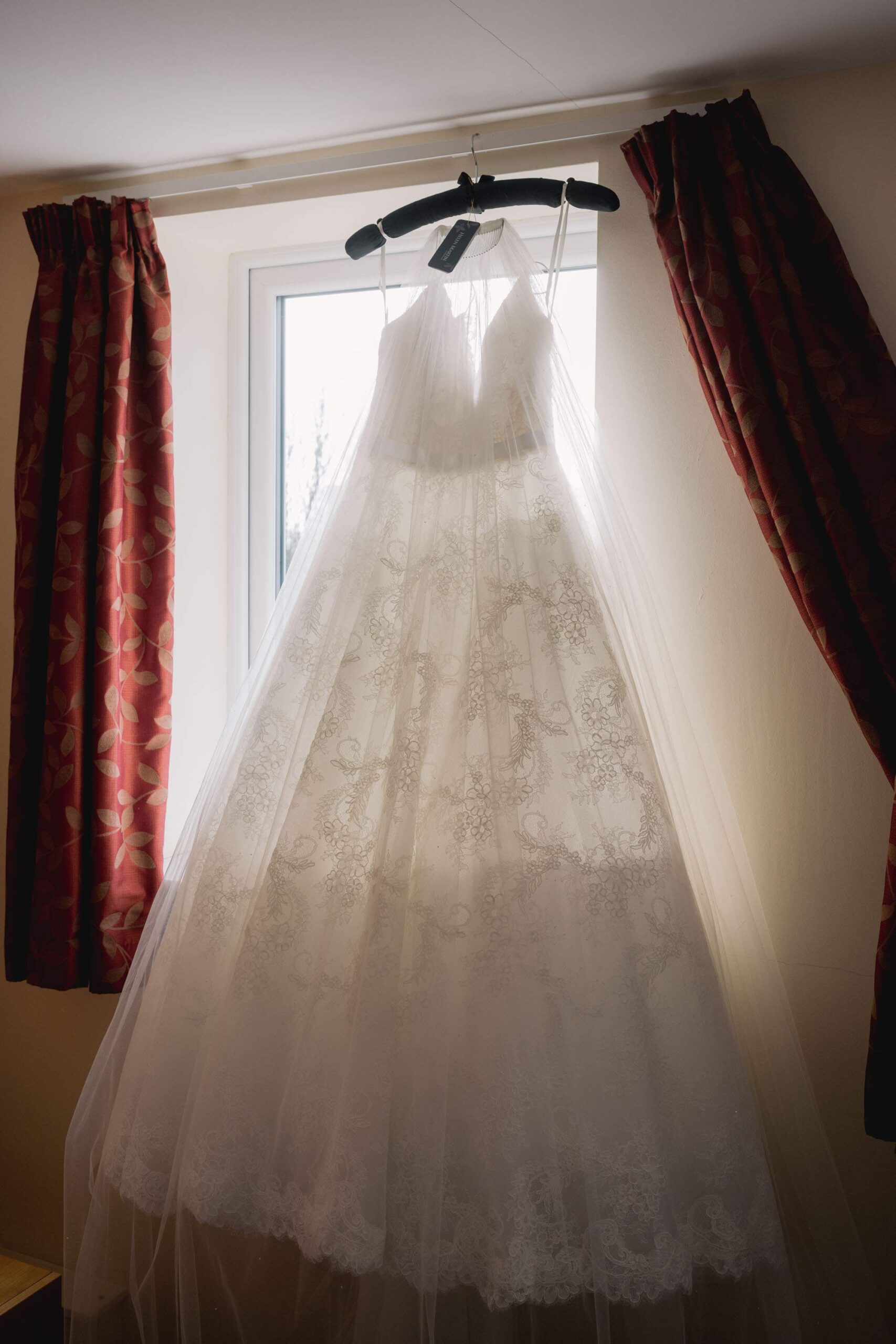 Wedding dress haging in the window.
