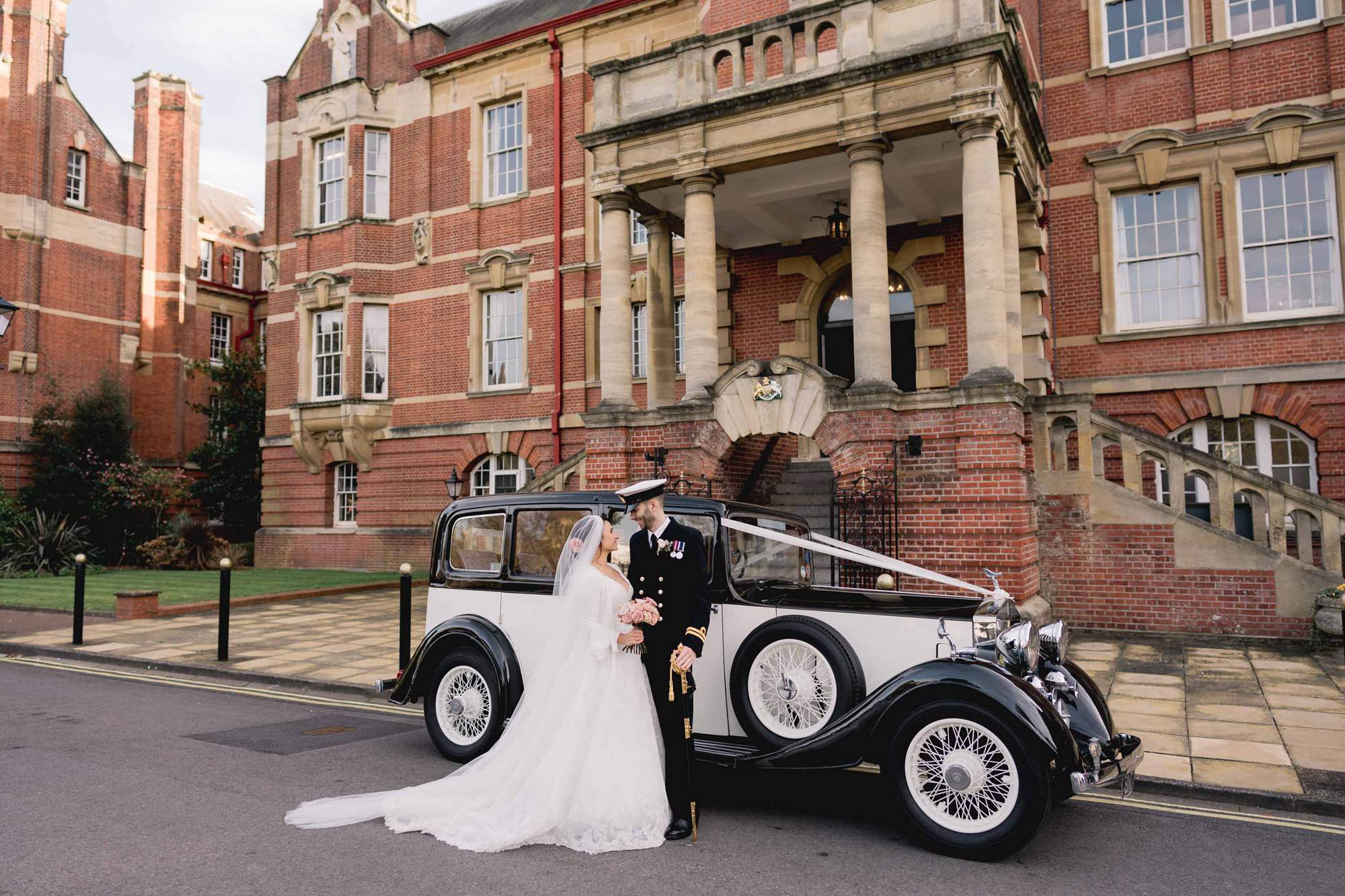 Bride and groom standing in front of a Rolls Royce vintage car outside the HMS Nelson Wardroom in Portsmouth.