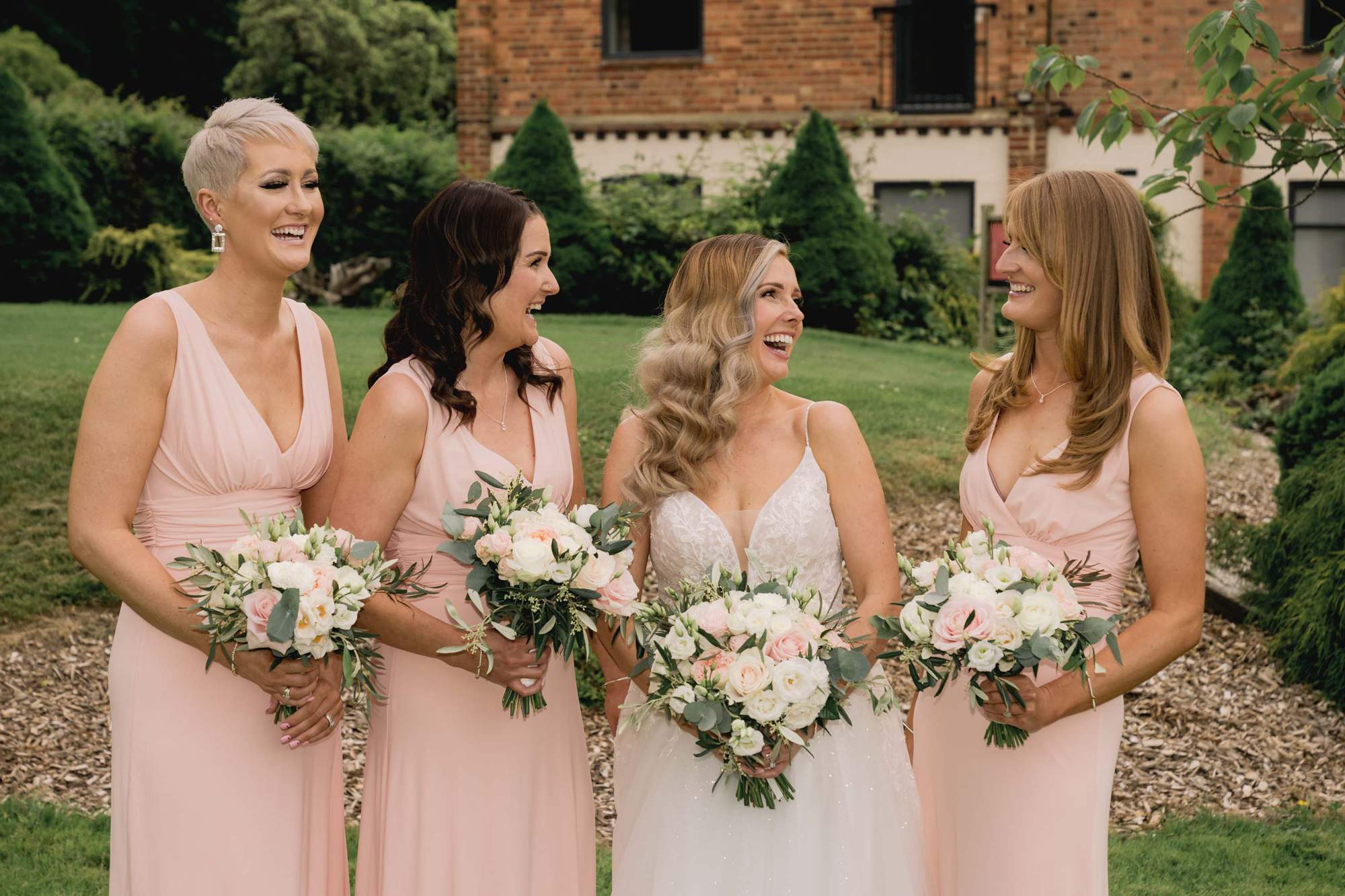 Bride laughs with her bridesmaids at Cottesmore Golf Club.