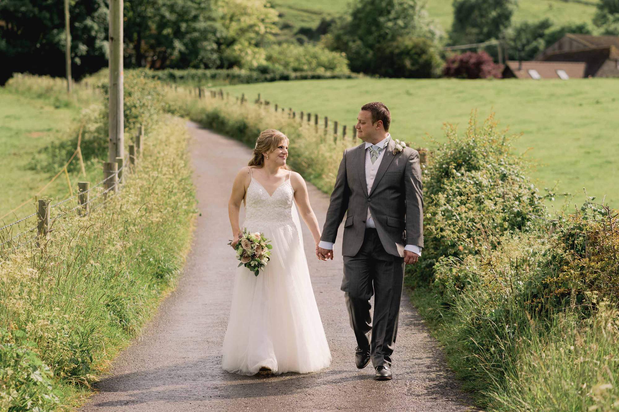 Bride and groom take a walk at Tottington Manor in the hills.