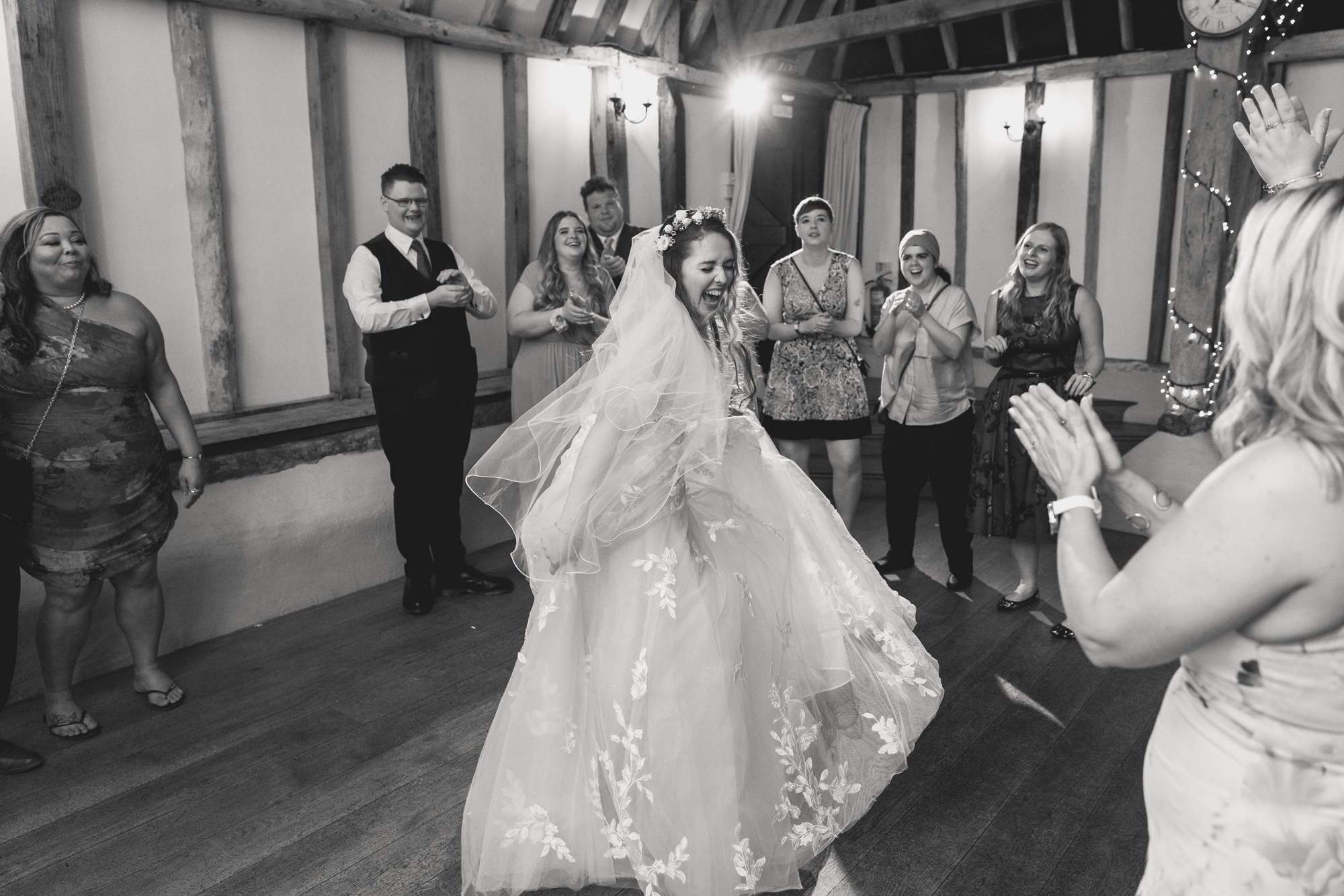 Bride dances with her wedding guests on the dance floor at the Clock Barn.