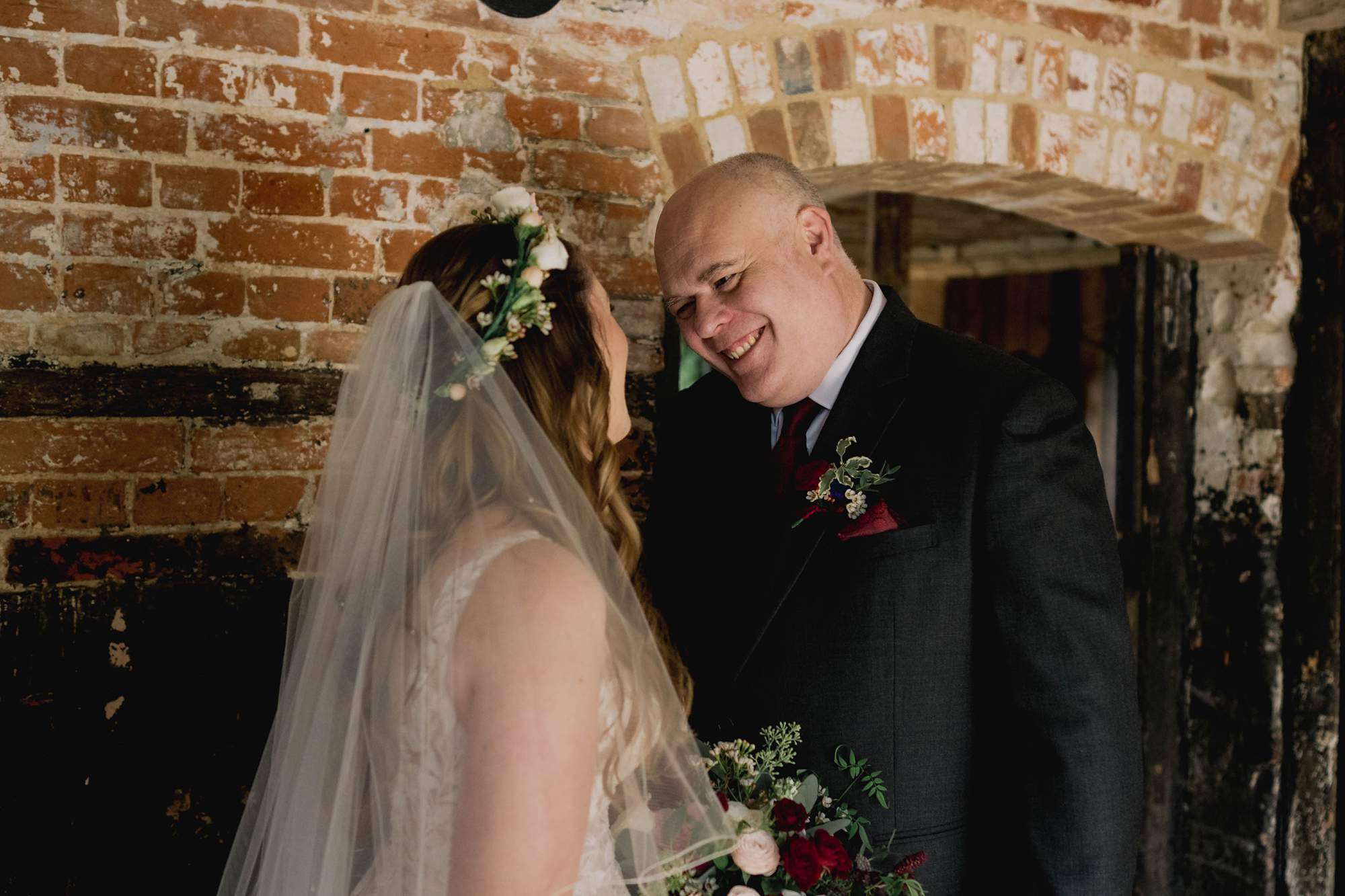 First look between a bride and her father on a wedding day at the Clock Barn venue in Hampshire.