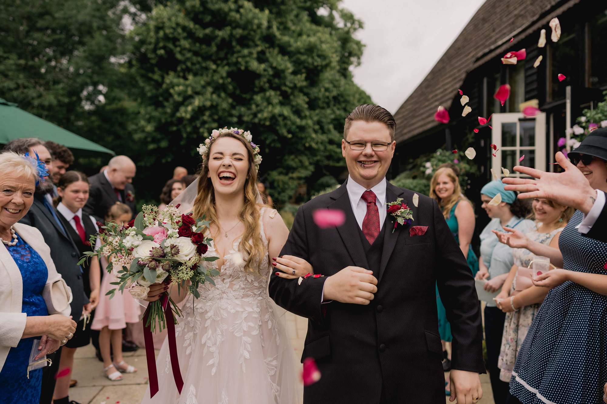Bride and groom have confetti thrown at them on their wedding day at the Clock Barn venue in Hampshire.