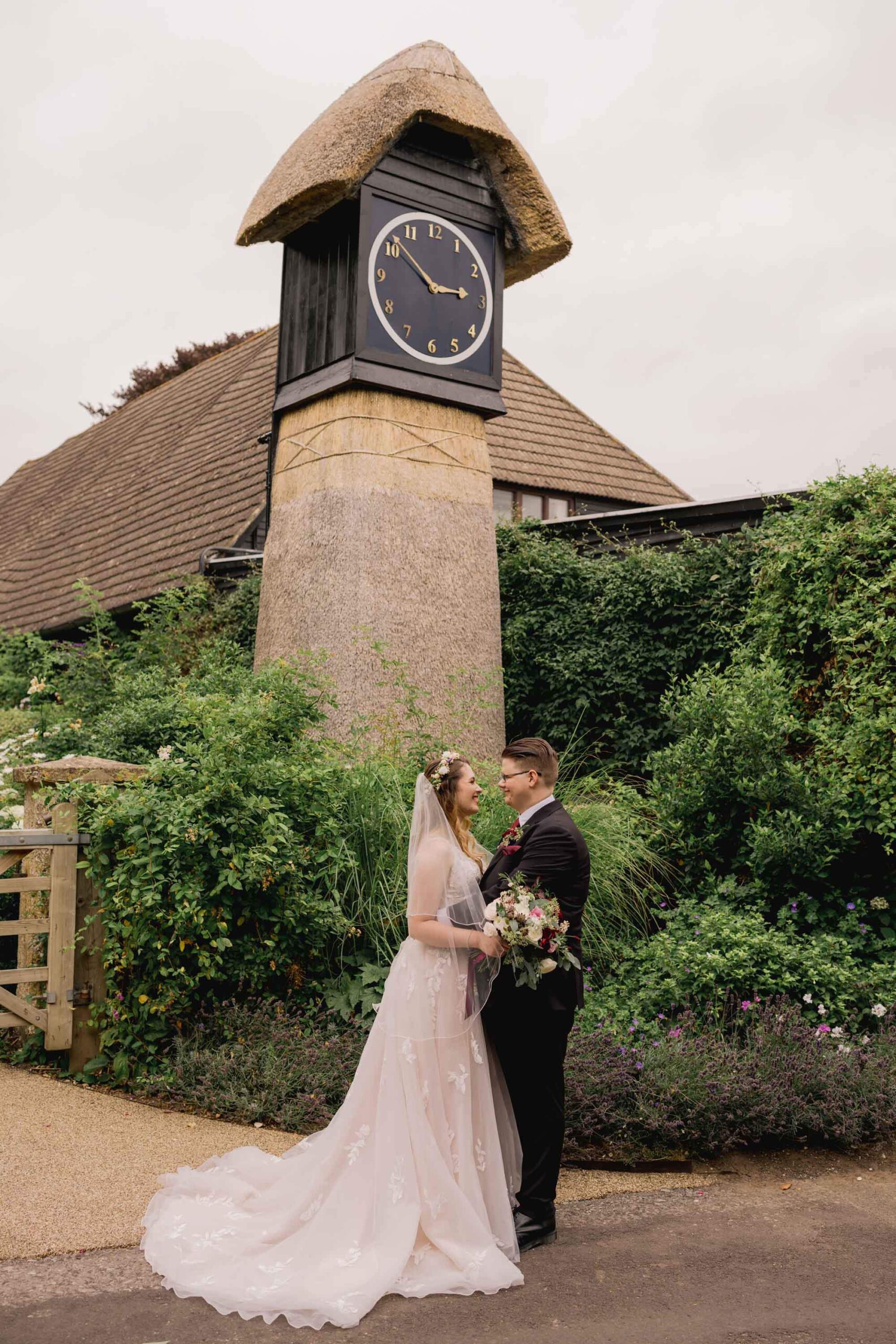 Bride and groom have a cuddle on their wedding day at the Clock Barn venue in Hampshire.