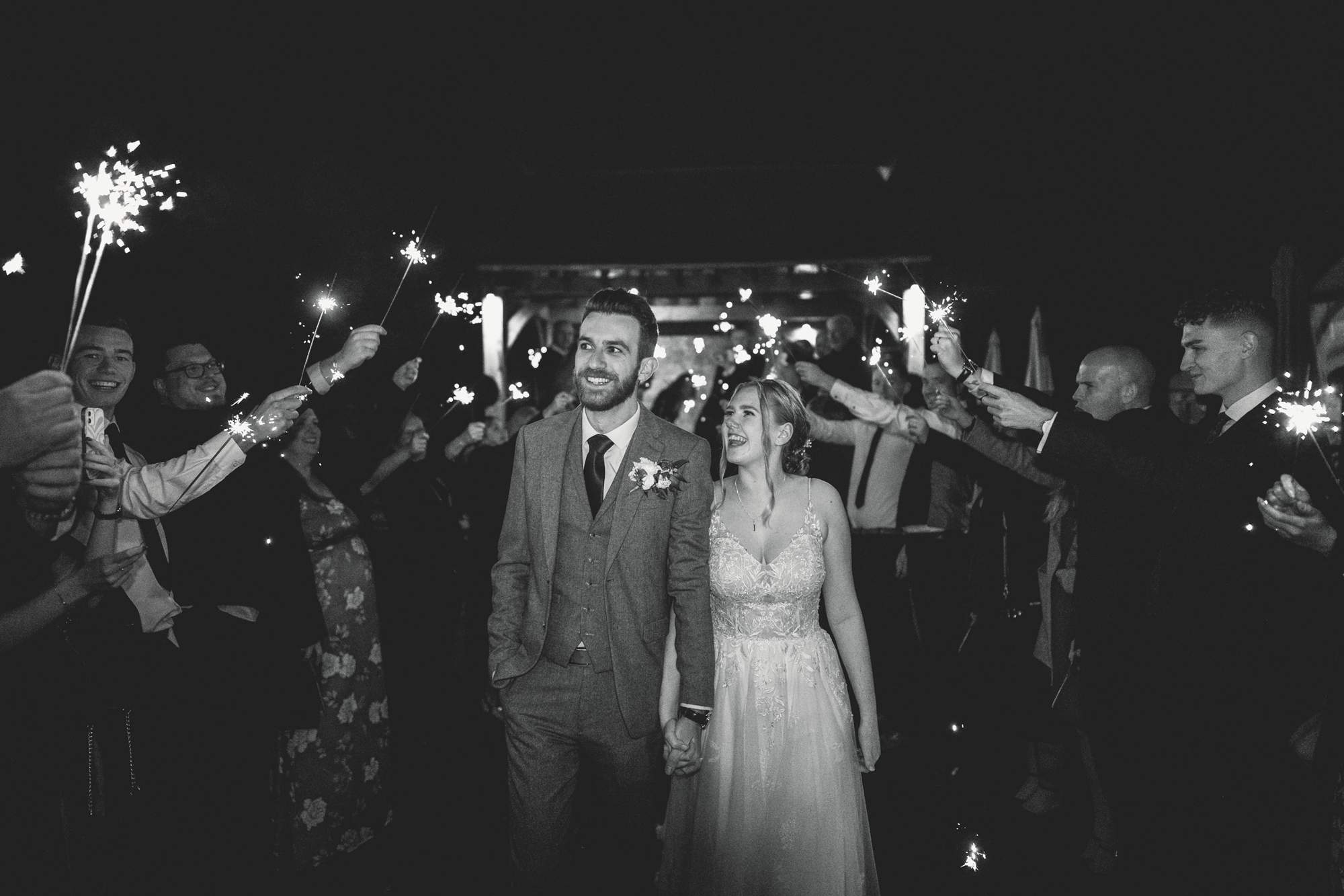 Bride and Groom walking through a sparkler exit on their wedding day at Farmhouse at Redcoats wedding venue.