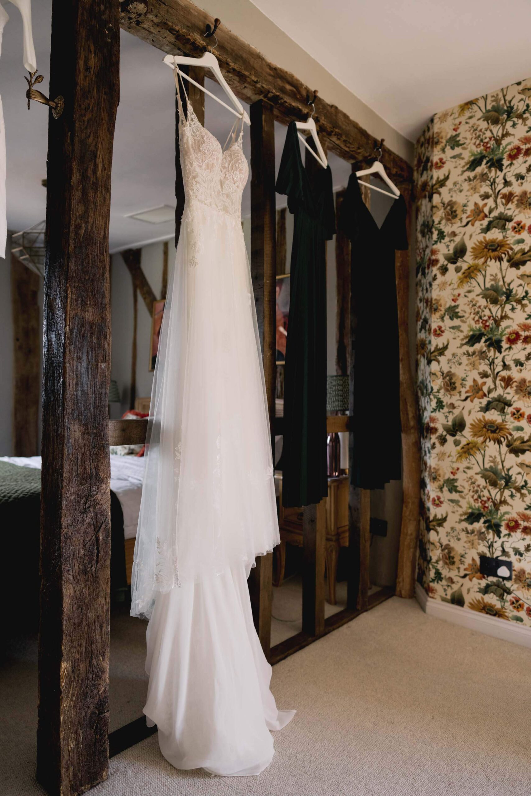Bride's wedding dress hanging on an exposed beam at The Farmhouse at Redcoats in Hitchin.