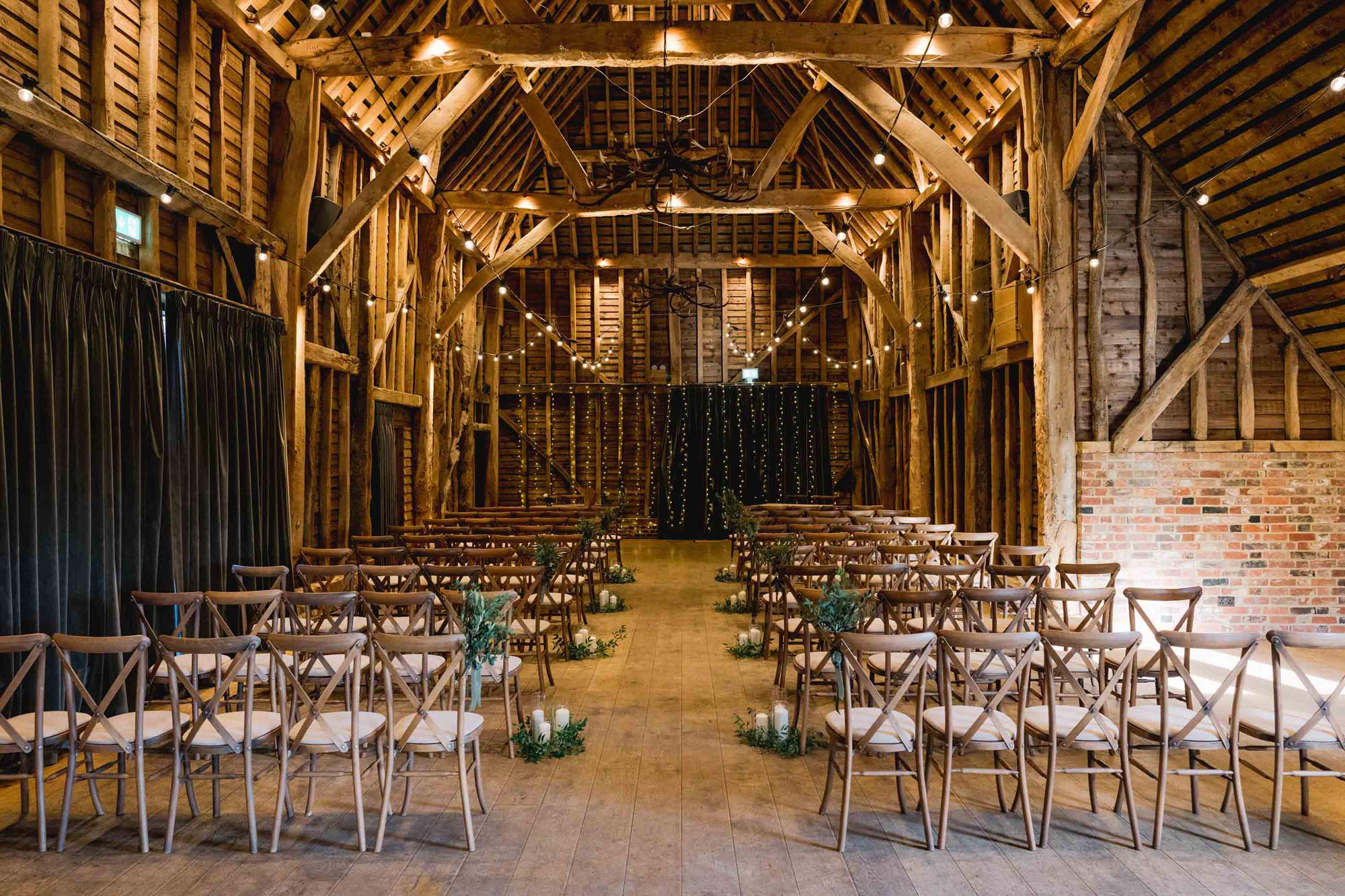 Wedding ceremony set up in the barn at The Farmhouse at Redcoats in Hitchin, Hertfordshire.