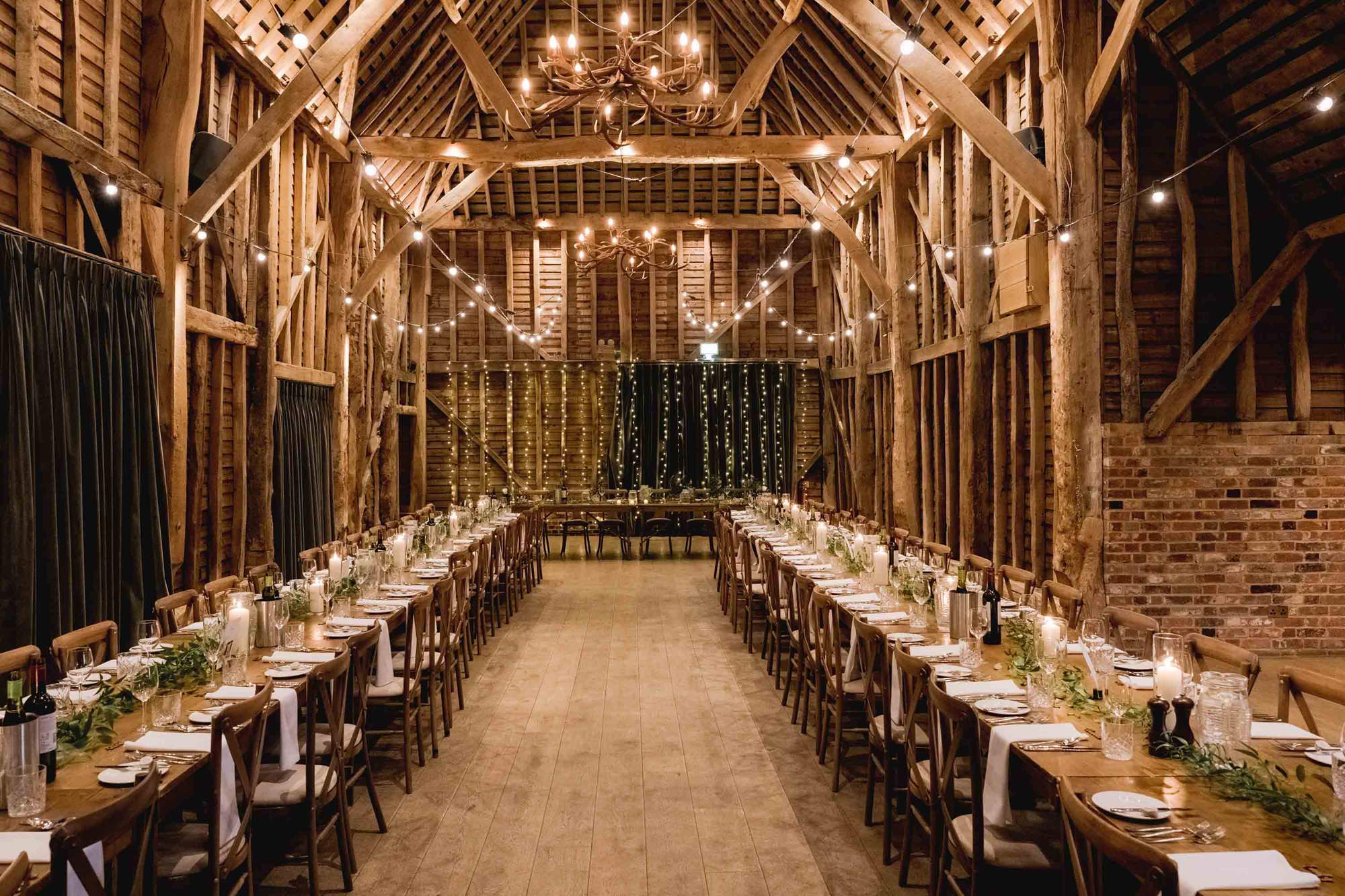 Interior of the barn set for the wedding breakfast at The Farmhouse at Redcoats in Hitchin.