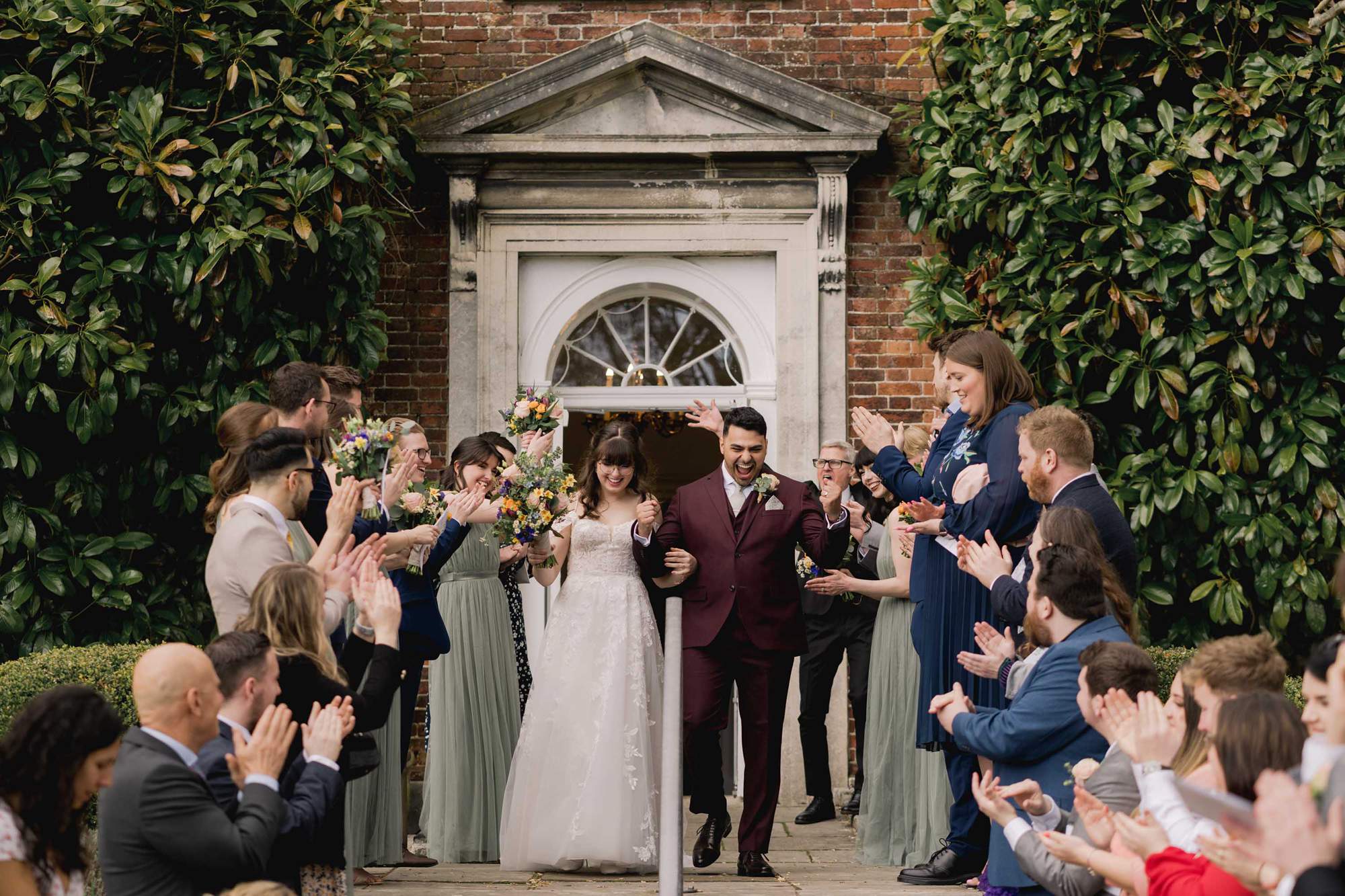Wedding guests throw confetti at the bride and groom on their wedding day at Pelham House in East Sussex.