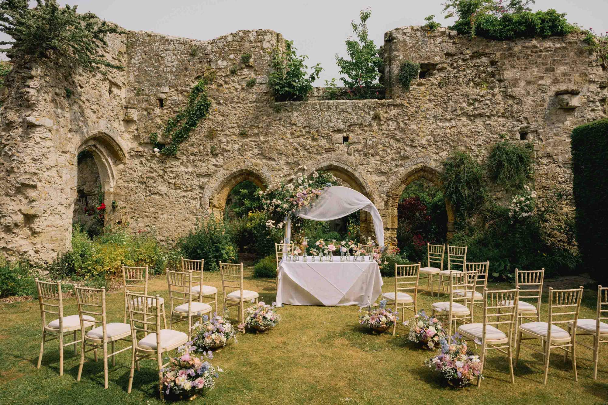 Pretty wedding ceremony set up in the garden at Amberley Castle in West Sussex.