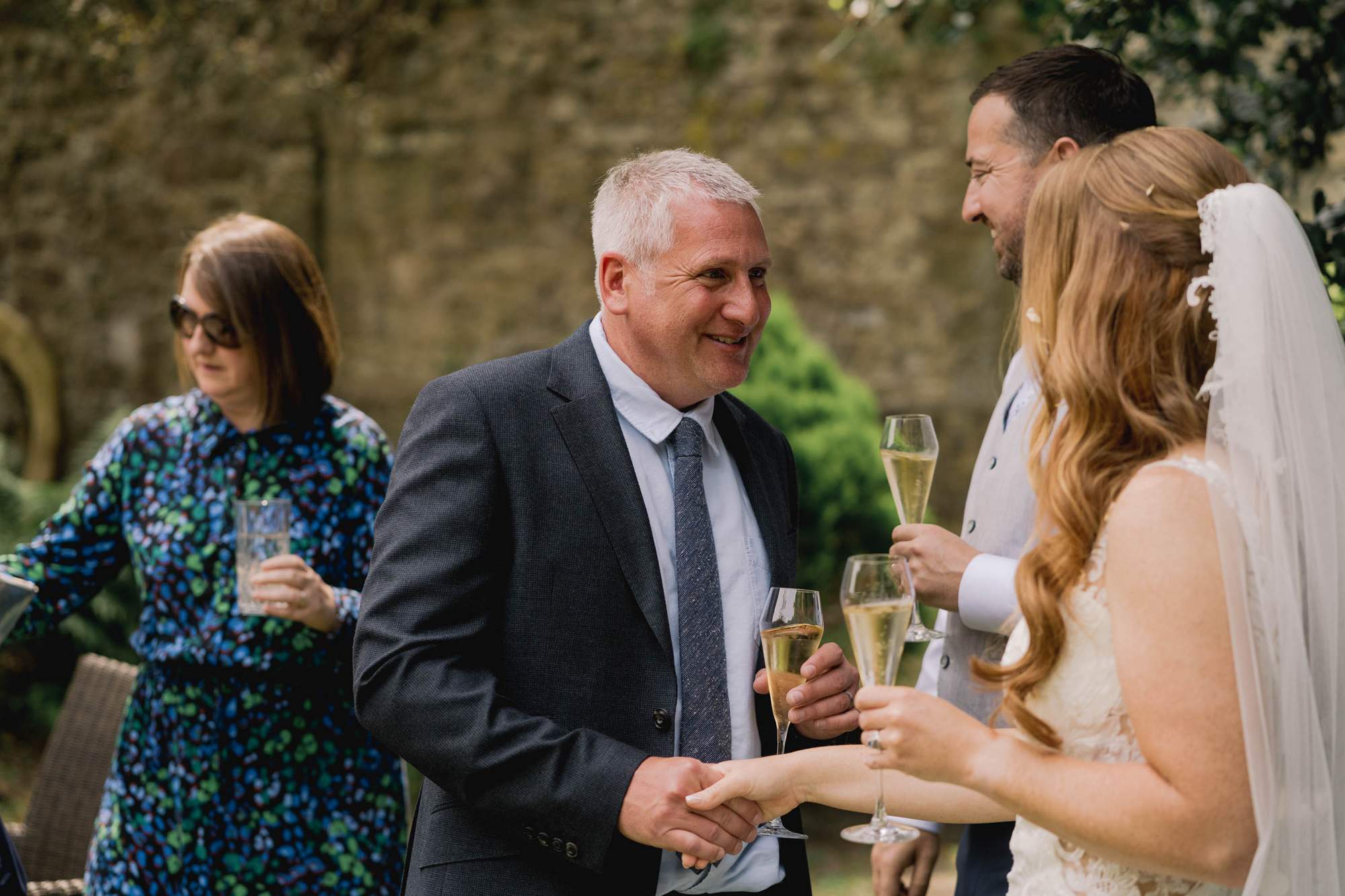 A guest smiling at a wedding in Amberley.