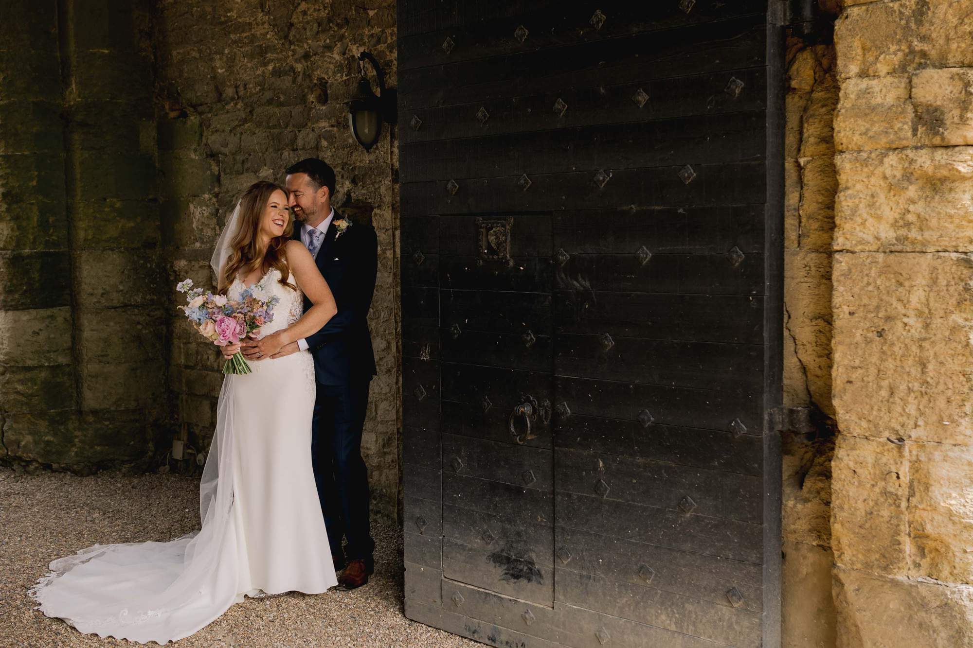 Bride and groom hug closely on their wedding day at Amberley Castle in West Sussex.